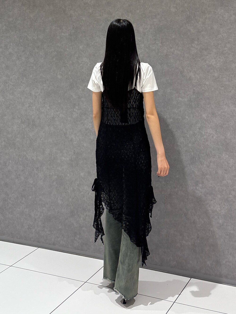 ブラック系のワンピース、ホワイト系のTシャツ/カットソー、ブルー系のデニムパンツを着用したレディースの夏コーディネートの3枚目の写真