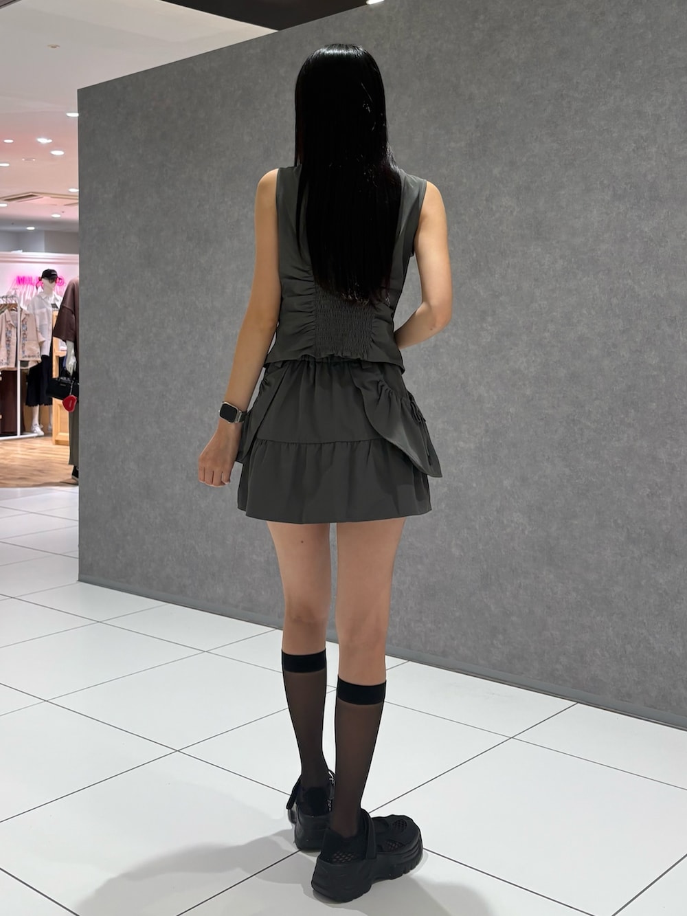 グレー系のTシャツ/カットソー、グレー系のスカート、ブラック系のスニーカーを着用したレディースの夏コーディネートの3枚目の写真