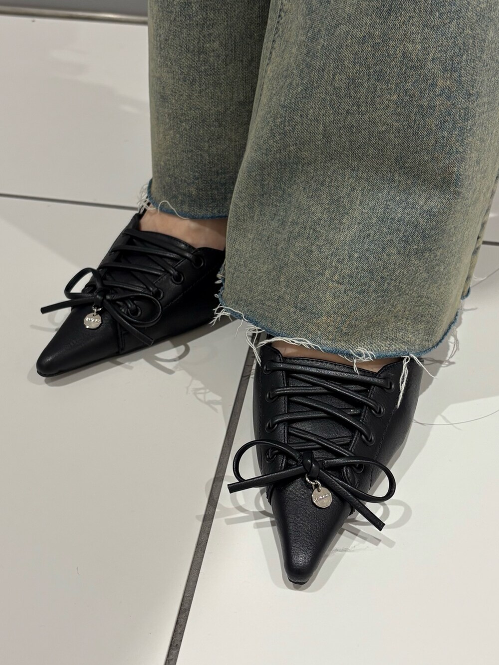 ブラック系のワンピース、ホワイト系のTシャツ/カットソー、ブルー系のデニムパンツを着用したレディースの夏コーディネートの7枚目の写真