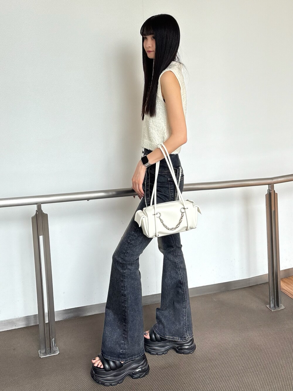 ブルー系のデニムパンツ、ホワイト系のニット/セーター、ブラック系のサンダルを着用したレディースの夏コーディネートの2枚目の写真