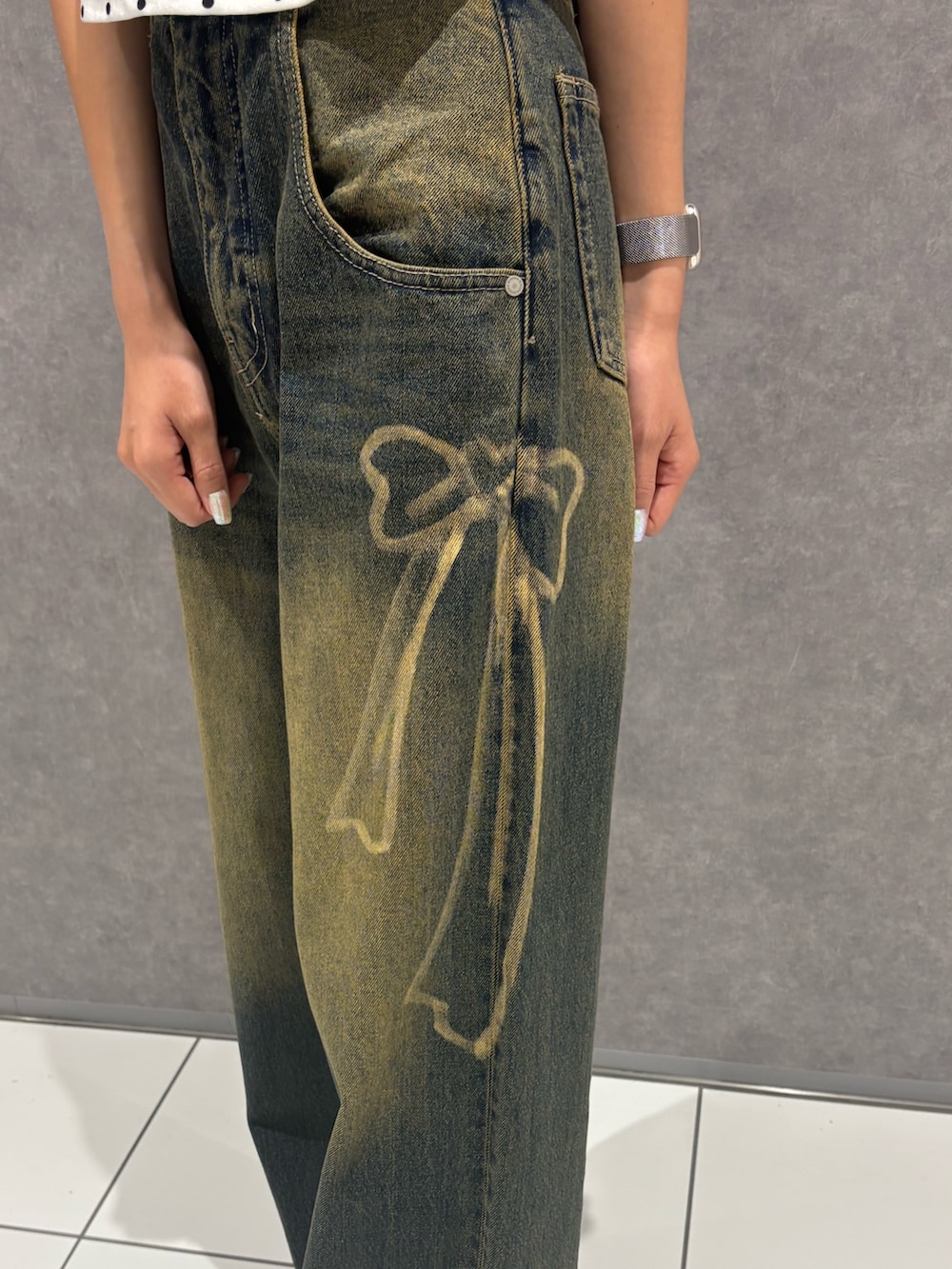 ホワイト系のタンクトップ、ブルー系のデニムパンツ、ブラック系のサンダルを着用したレディースの夏コーディネートの6枚目の写真