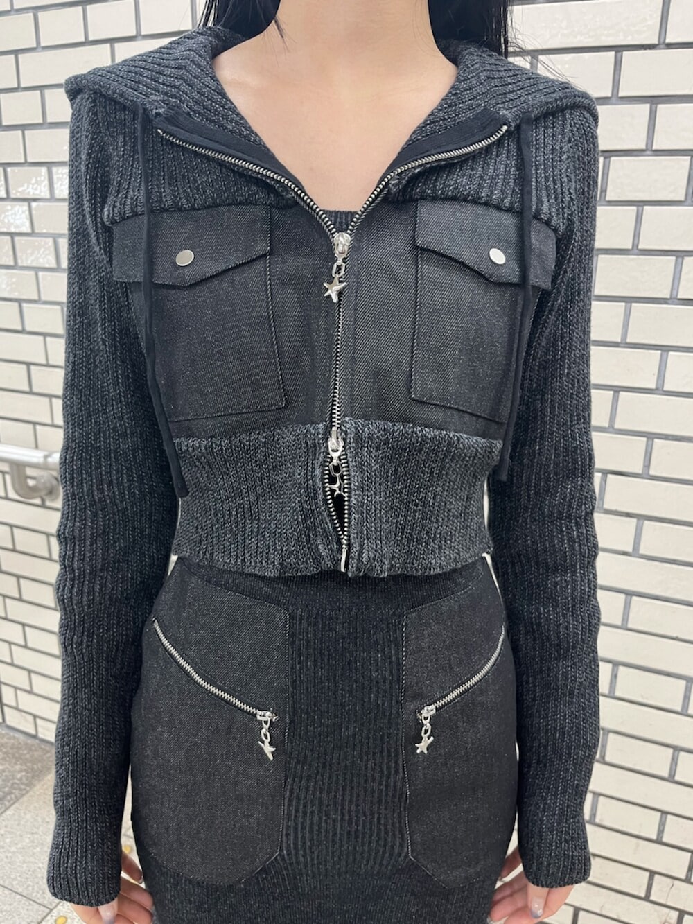 ブラック系のブーツ、ブラック系のニット/セーター、ブラック系のワンピースを着用したレディースの春コーディネートの5枚目の写真