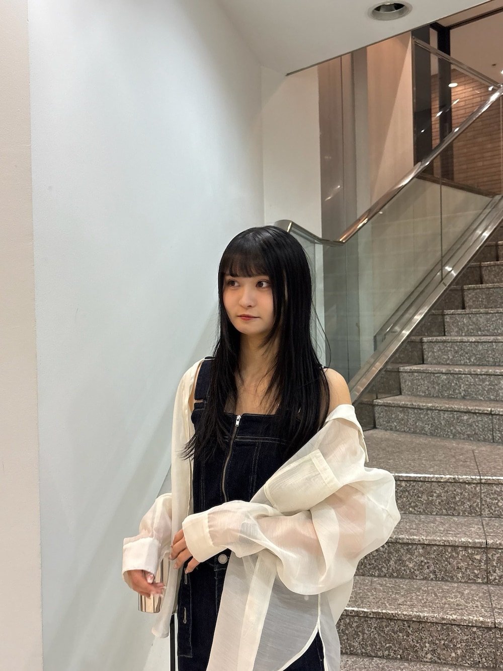 ブラック系のサンダル、ブルー系のサロペット/オーバーオール、ホワイト系のシャツ/ブラウスを着用したレディースの春コーディネートの4枚目の写真