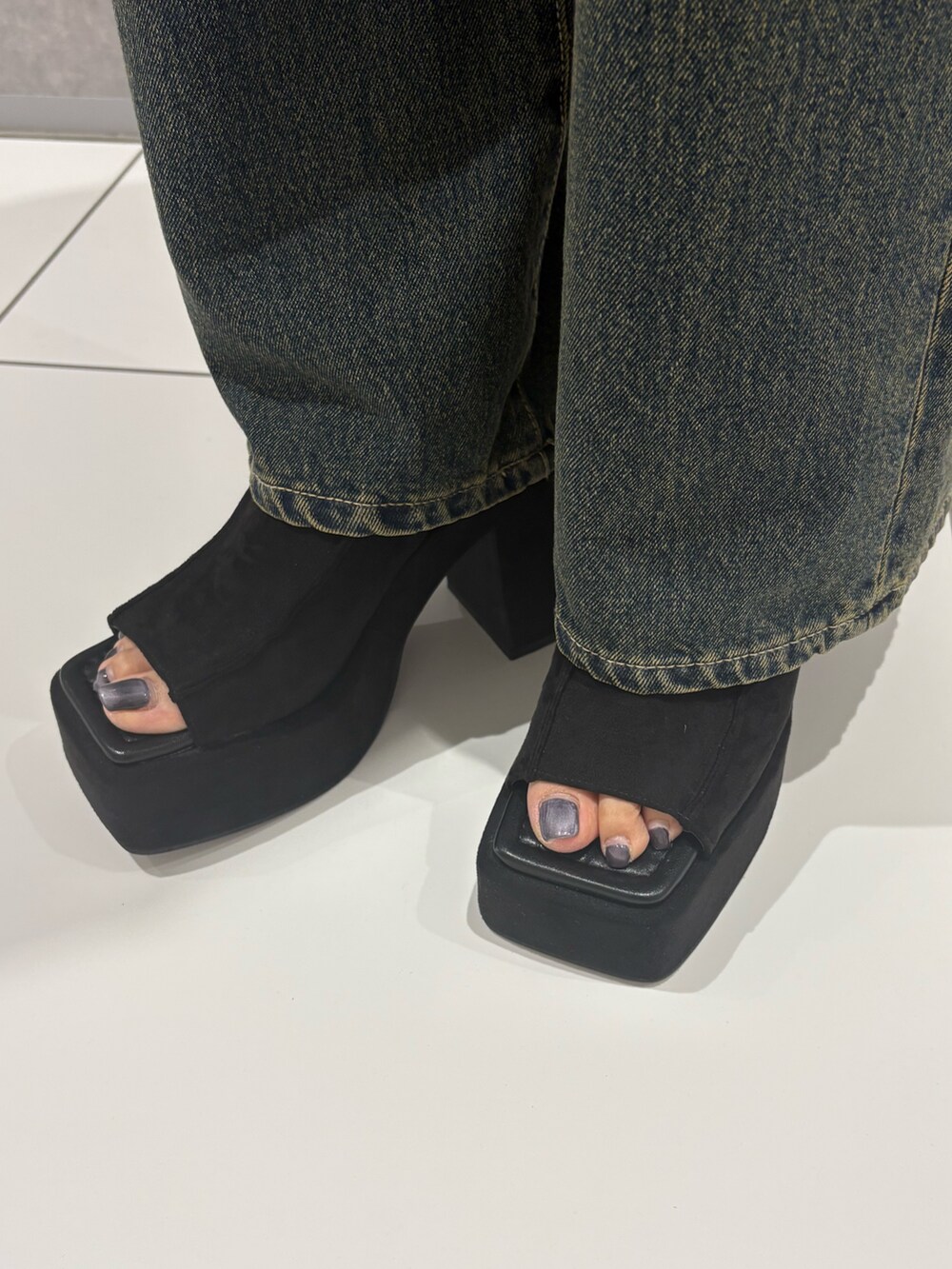 ホワイト系のタンクトップ、ブルー系のデニムパンツ、ブラック系のサンダルを着用したレディースの夏コーディネートの7枚目の写真