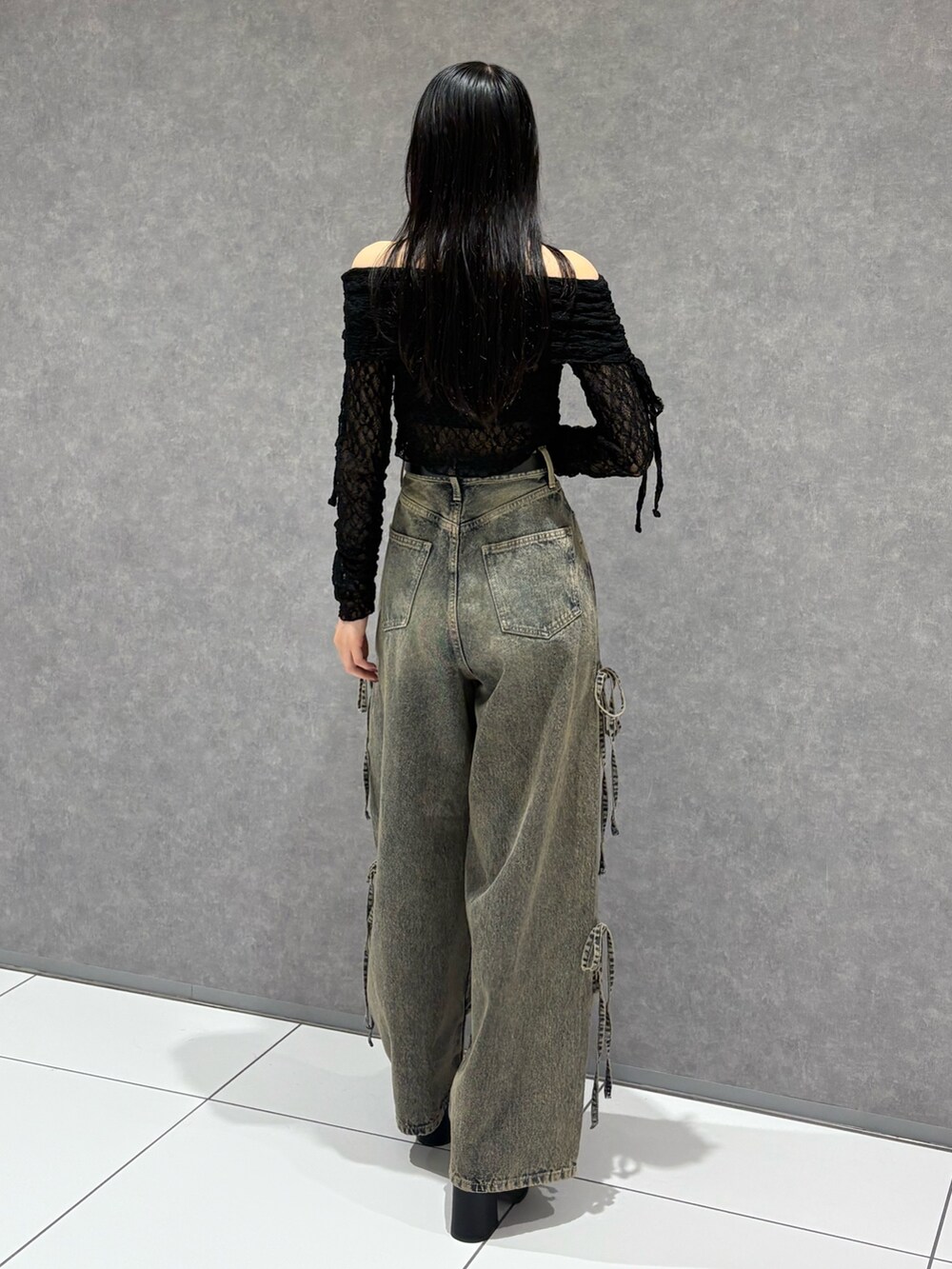 ブラック系のTシャツ/カットソー、ブルー系のデニムパンツ、ブラック系のサンダルを着用したレディースの春コーディネートの3枚目の写真