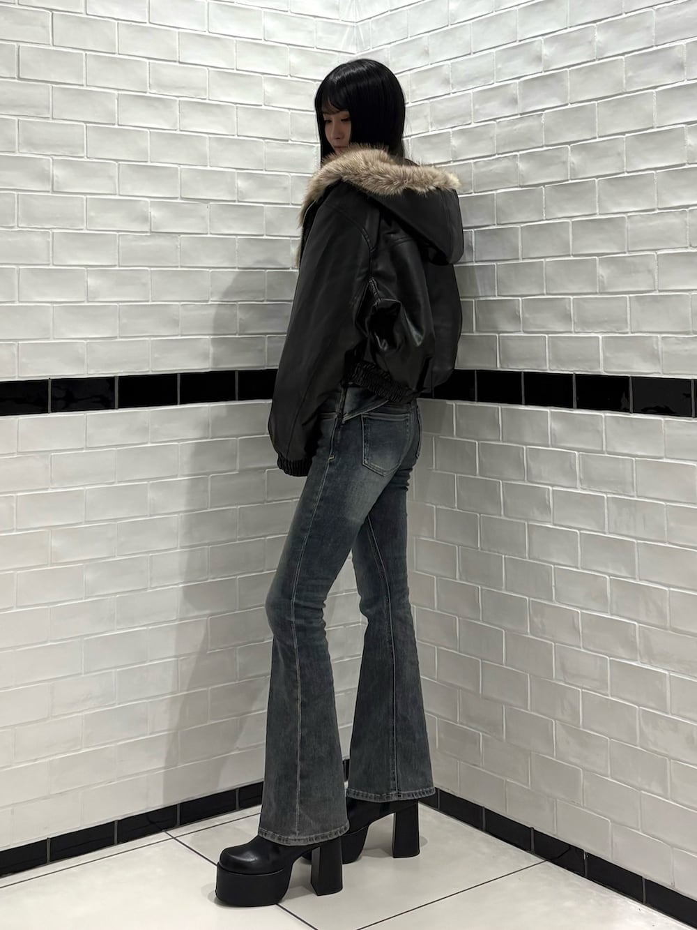ブラック系のTシャツ/カットソー、ブラック系のブルゾン、ブルー系のデニムパンツを着用したレディースの秋コーディネートの2枚目の写真