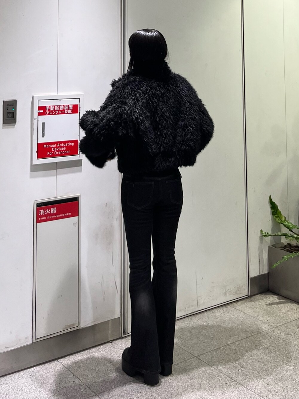 ブラック系のデニムパンツ、ブラック系のブルゾン、ブラック系のブーツを着用したレディースの秋コーディネートの3枚目の写真