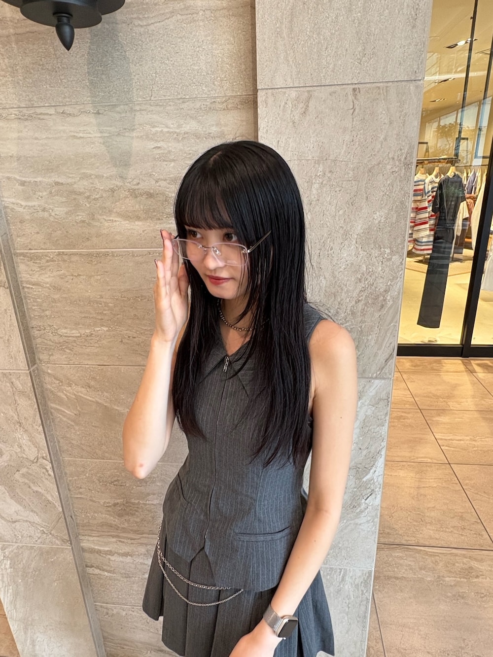 グレー系のワンピース、ホワイト系のサンダル、ホワイト系のハンドバッグを着用したレディースの春コーディネートの4枚目の写真