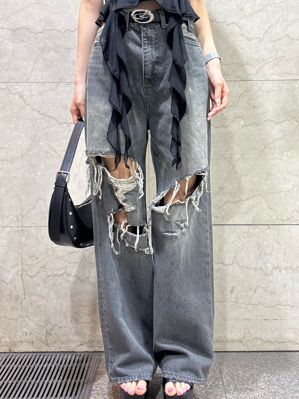 ブラック系のTシャツ/カットソー、ブラック系のニット/セーター、ブラック系のデニムパンツを着用したレディースの春コーディネートの6枚目の写真