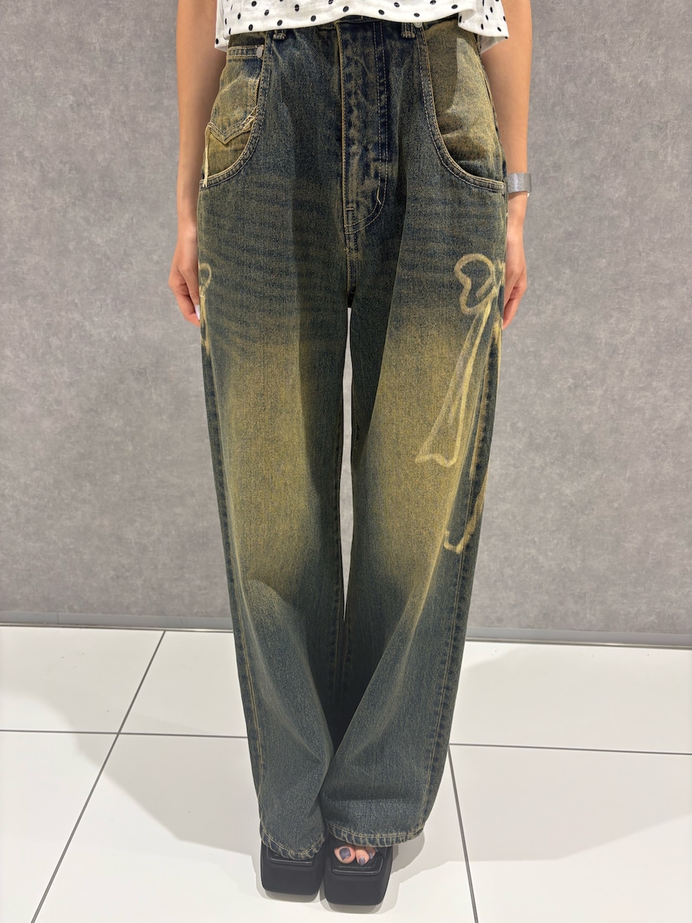 ホワイト系のタンクトップ、ブルー系のデニムパンツ、ブラック系のサンダルを着用したレディースの夏コーディネートの5枚目の写真