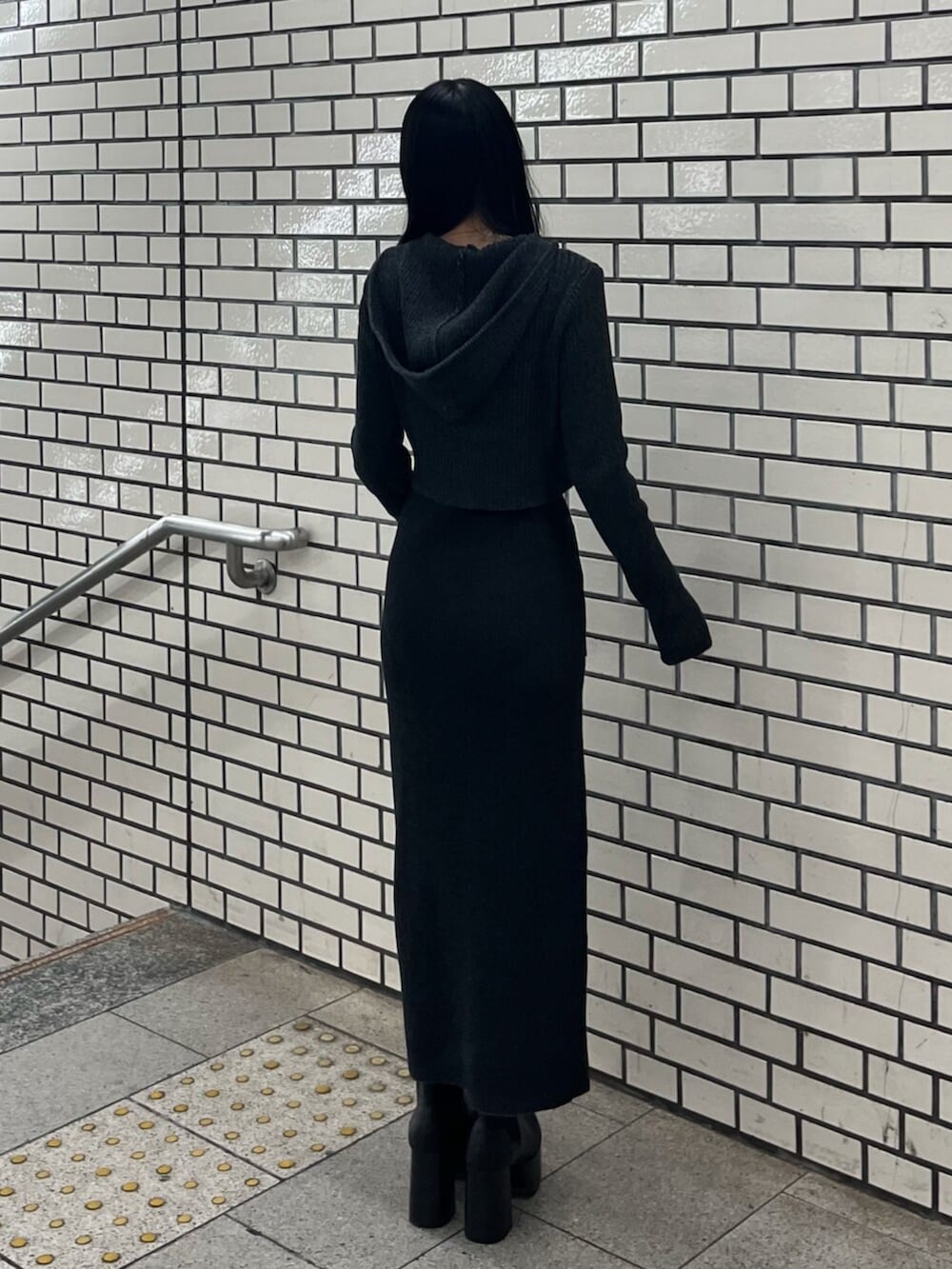 ブラック系のブーツ、ブラック系のニット/セーター、ブラック系のワンピースを着用したレディースの春コーディネートの3枚目の写真