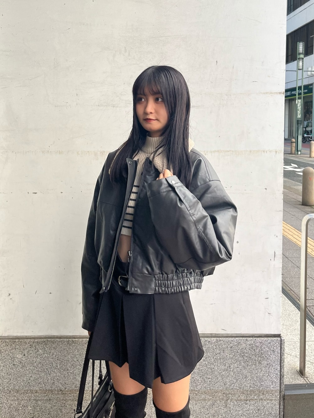 グレー系のブルゾン、ホワイト系のニット/セーター、ブラック系のスカートを着用したレディースの秋コーディネートの4枚目の写真