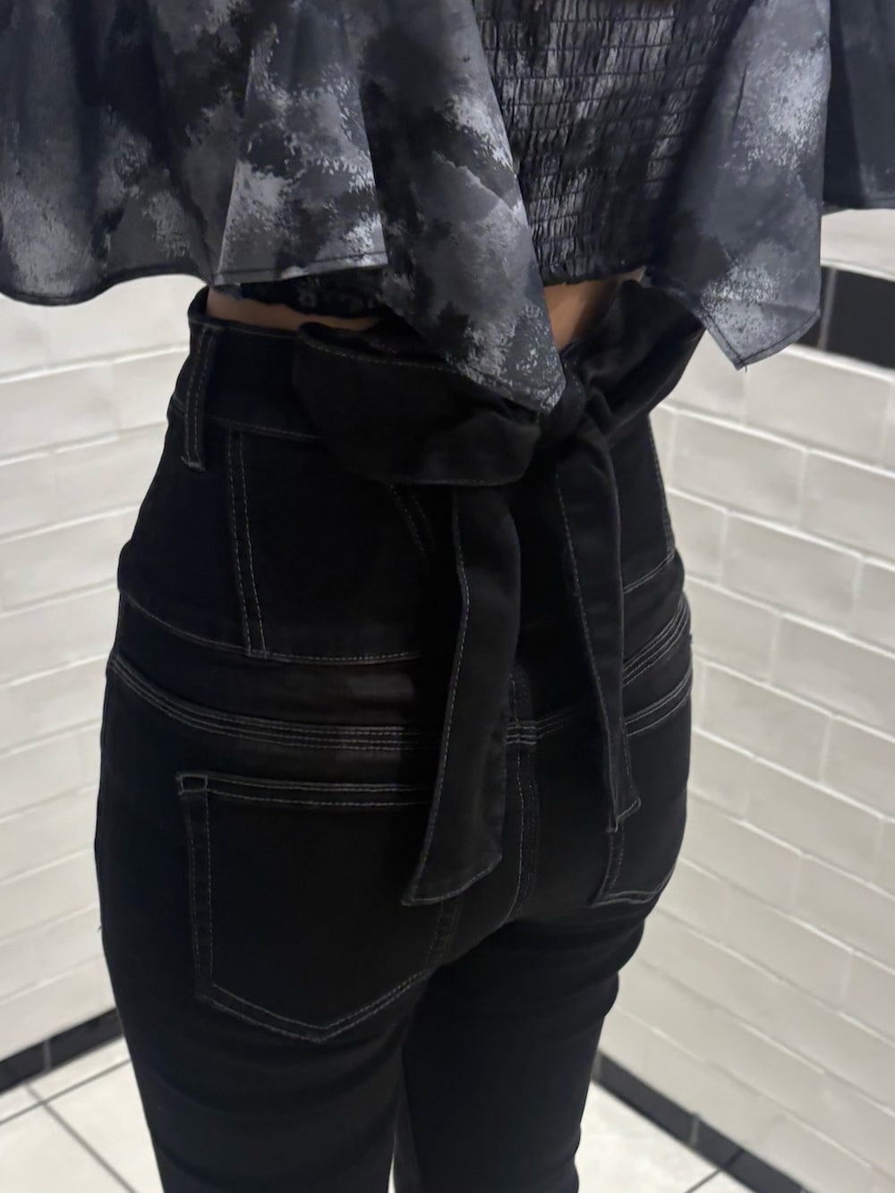 ブラック系のデニムパンツ、ブラック系のサンダルを着用したレディースの秋コーディネートの4枚目の写真
