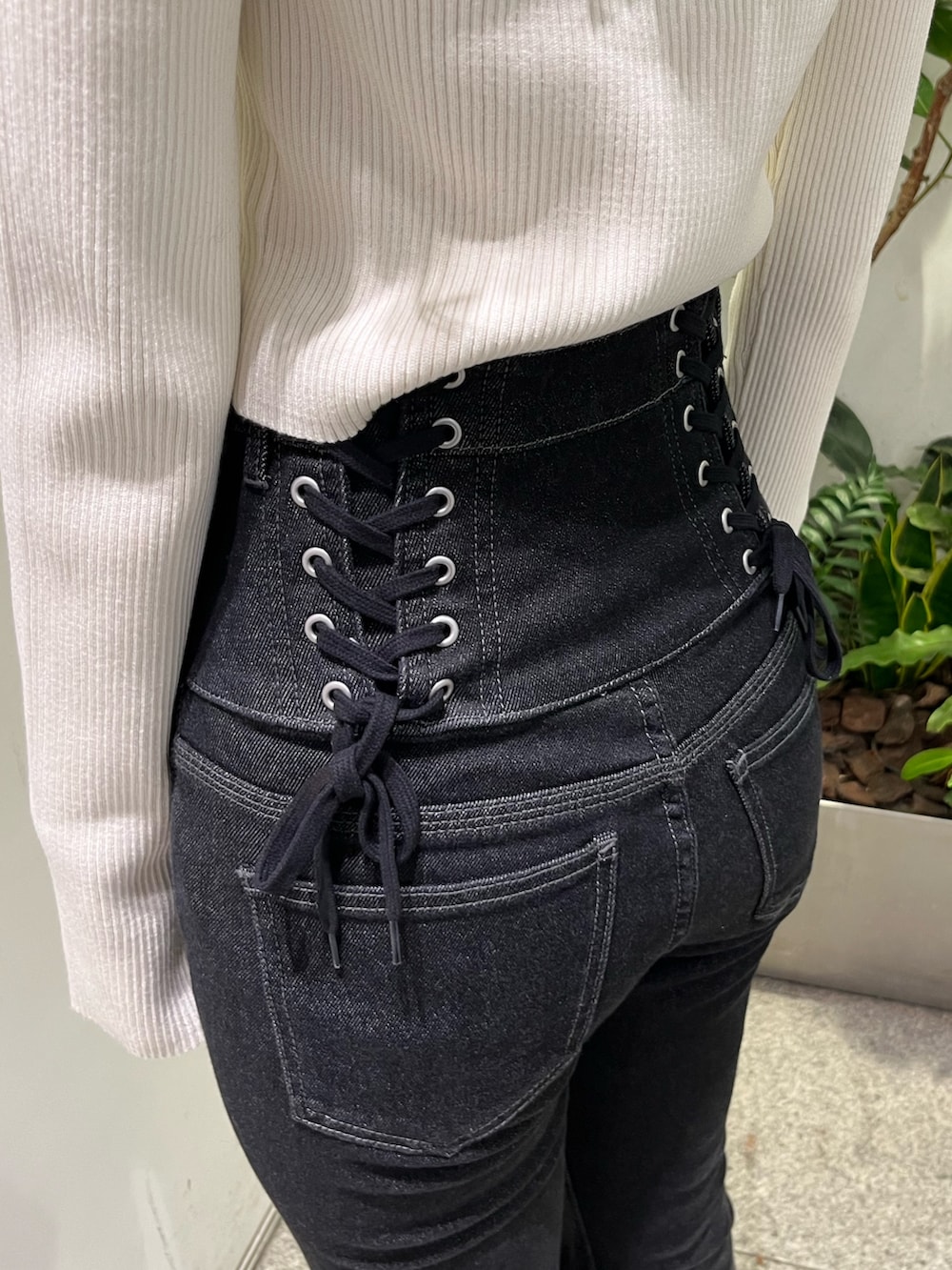 ブラック系のデニムパンツ、ブラック系のブルゾン、ブラック系のブーツを着用したレディースの秋コーディネートの8枚目の写真