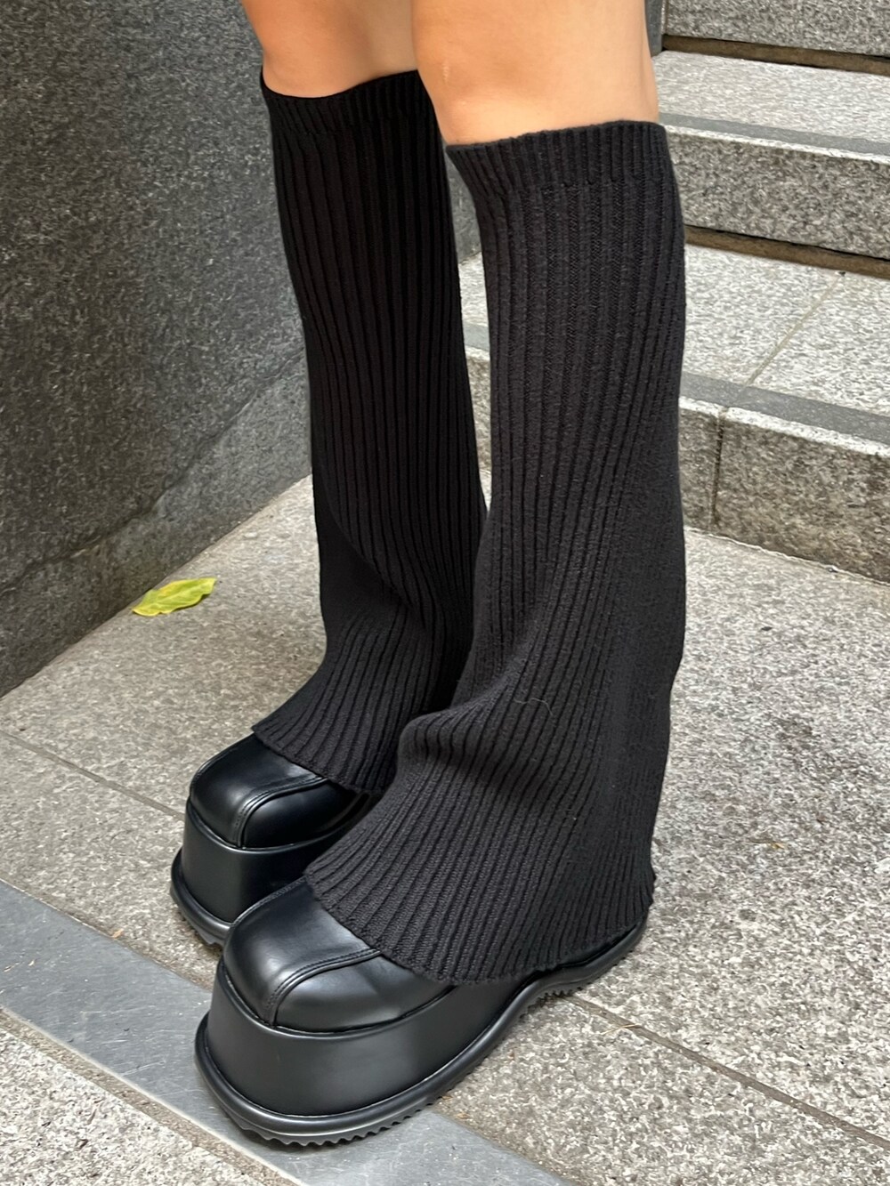 ブラック系のニット/セーター、ブラック系のスカート、ホワイト系のブルゾンを着用したレディースの秋コーディネートの8枚目の写真