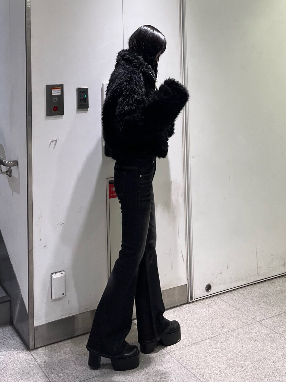 ブラック系のデニムパンツ、ブラック系のブルゾン、ブラック系のブーツを着用したレディースの秋コーディネートの2枚目の写真