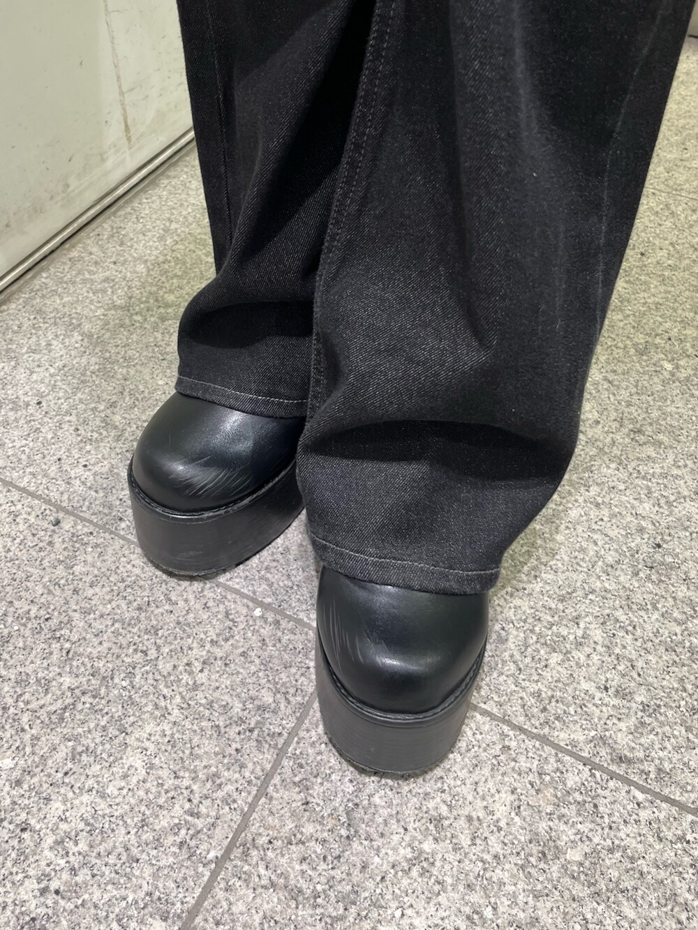 ブラック系のデニムパンツ、ブラック系のブルゾン、ブラック系のブーツを着用したレディースの秋コーディネートの9枚目の写真