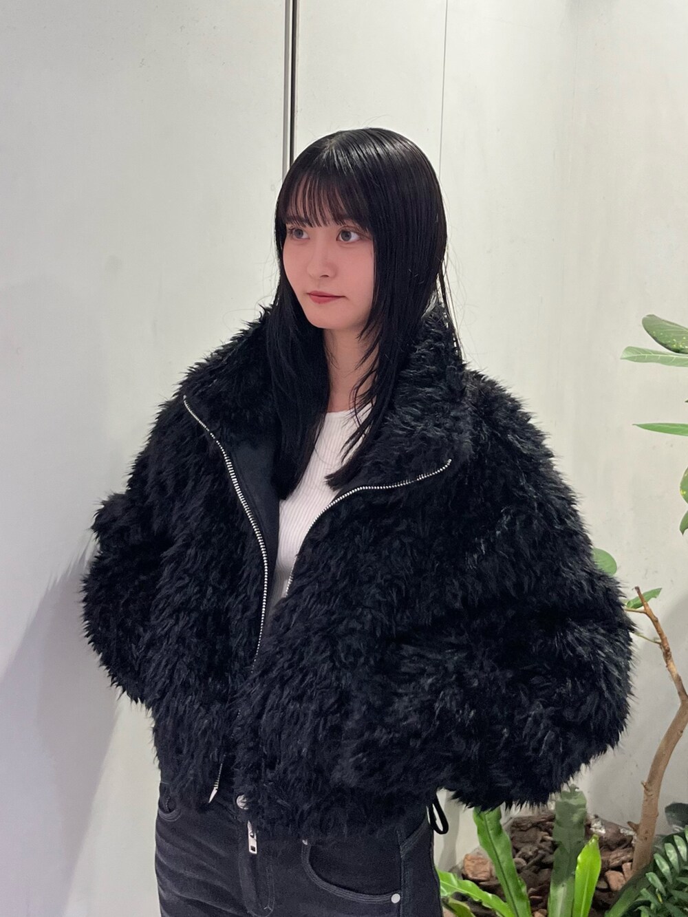 ブラック系のデニムパンツ、ブラック系のブルゾン、ブラック系のブーツを着用したレディースの秋コーディネートの4枚目の写真