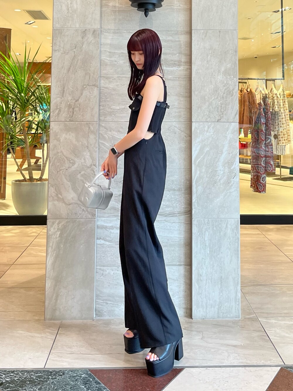 ブラック系のつなぎ/オールインワン、シルバー系のハンドバッグ、ブラック系のサンダルを着用したレディースの夏コーディネートの2枚目の写真