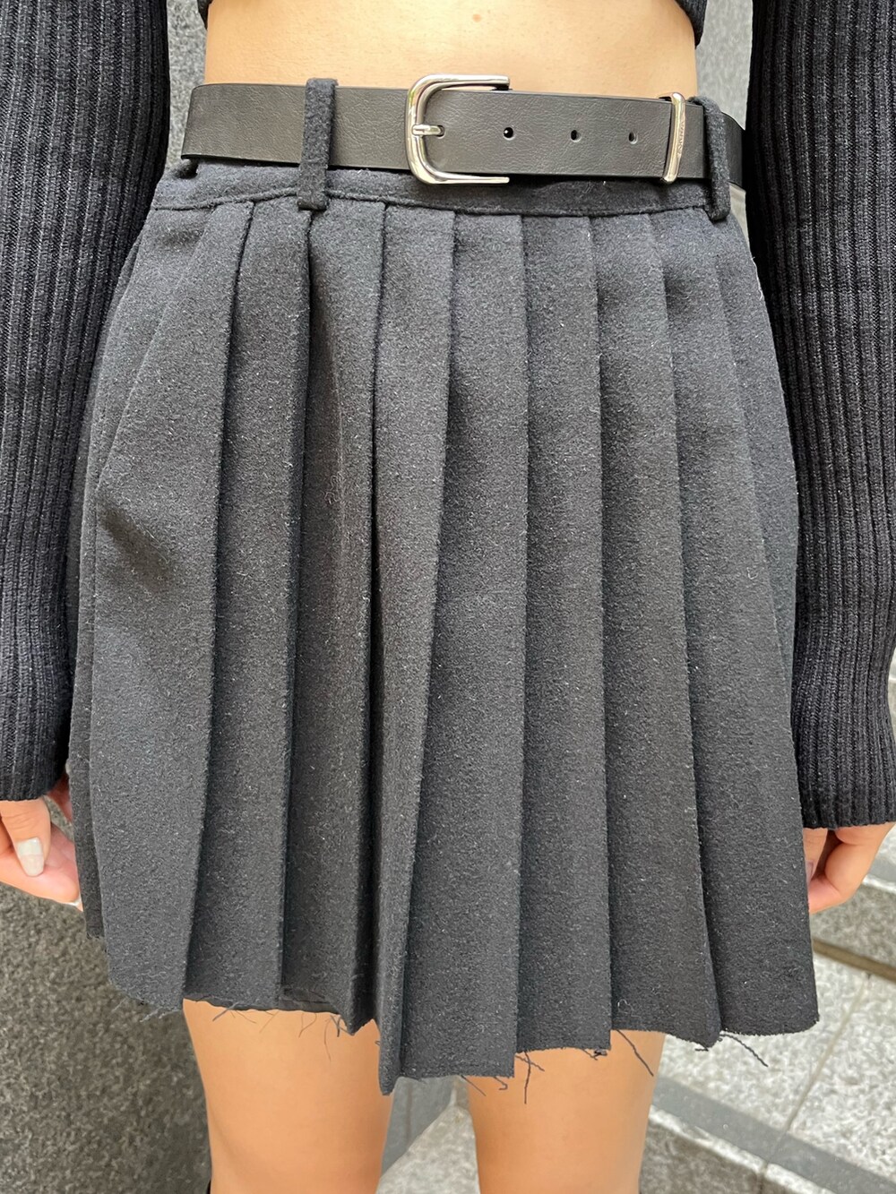 ブラック系のニット/セーター、ブラック系のスカート、ホワイト系のブルゾンを着用したレディースの秋コーディネートの7枚目の写真