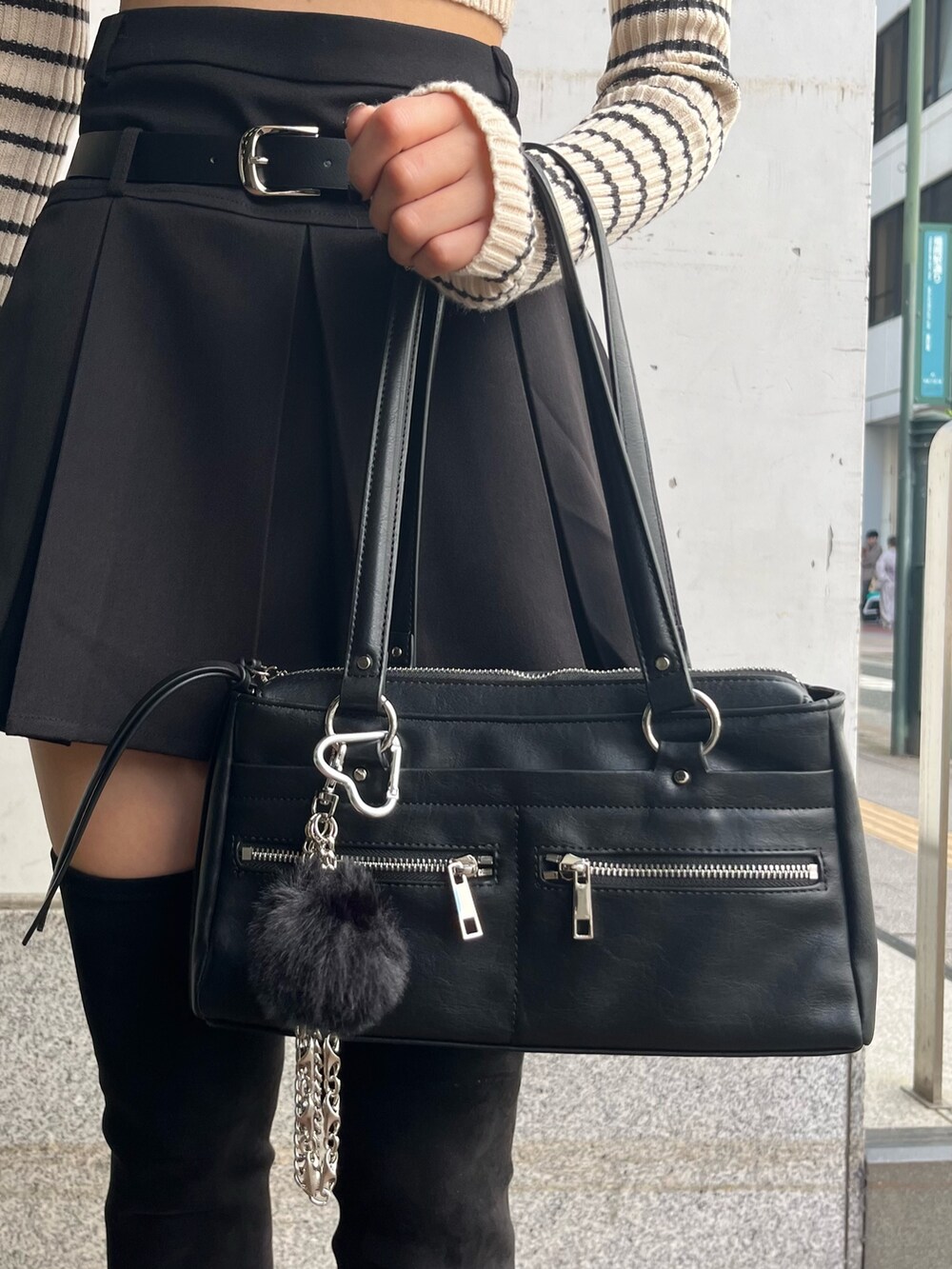 グレー系のブルゾン、ホワイト系のニット/セーター、ブラック系のスカートを着用したレディースの秋コーディネートの9枚目の写真