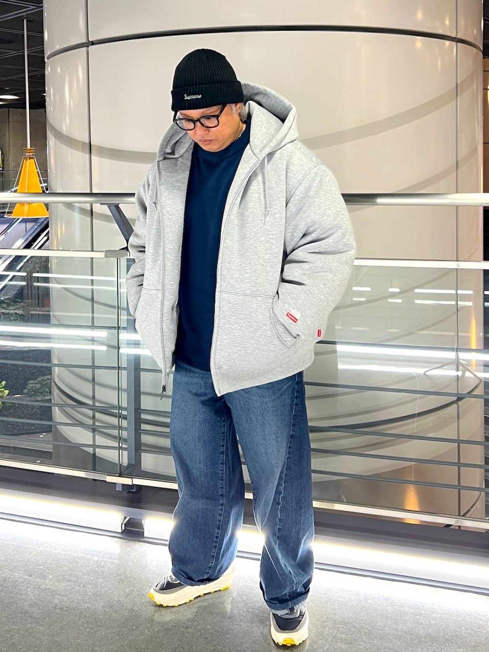 グレー系のダウンジャケット/コート、ブルー系のニット/セーター、ブラック系のニットキャップ/ビーニーを着用したメンズの冬コーディネートの2枚目の写真