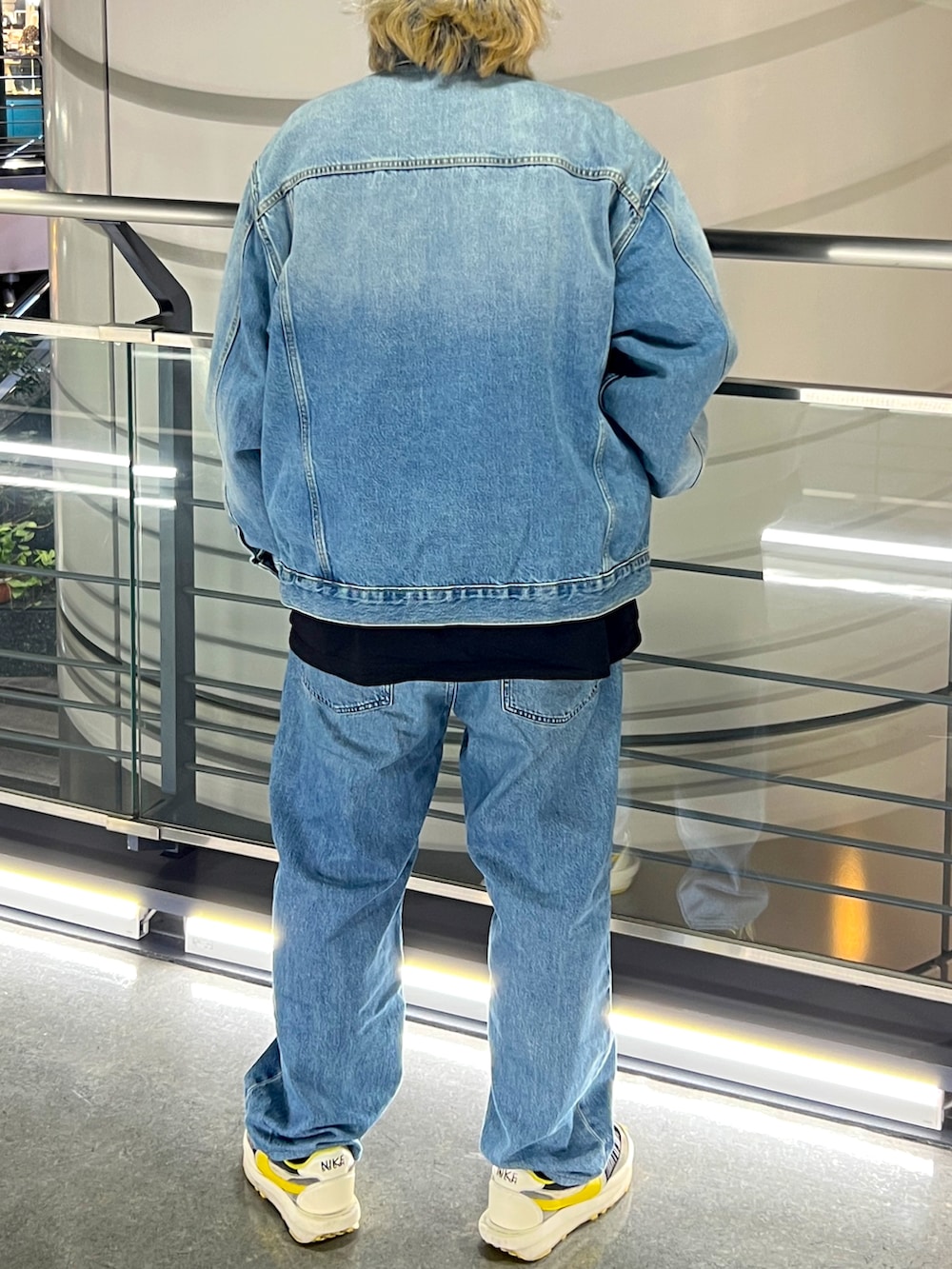 ブルー系のデニムジャケット、ブルー系のデニムパンツ、ブラック系のキャップを着用したメンズの春コーディネートの2枚目の写真