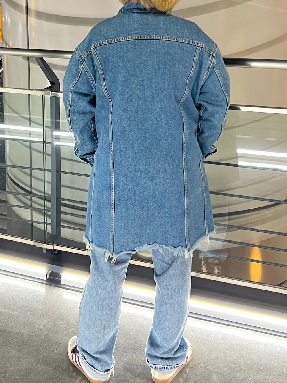 グレー系のスウェット、ブルー系のデニムパンツ、ブルー系のデニムジャケットを着用したメンズの春コーディネートの2枚目の写真