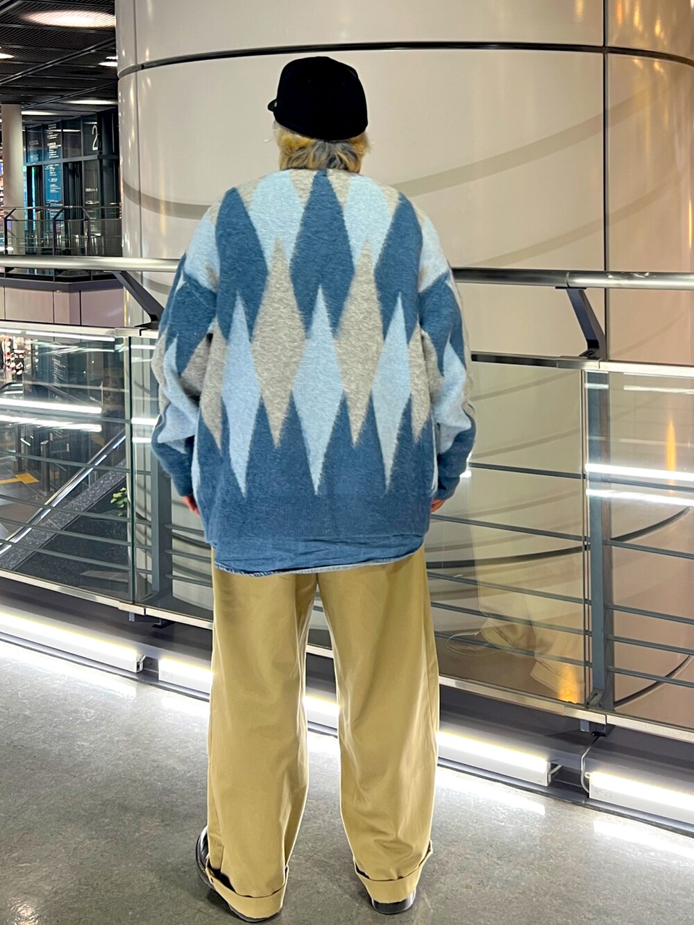 ブルー系のシャツ/ブラウス、ベージュ系のチノパンツ、ブラック系のブーツを着用したメンズの冬コーディネートの2枚目の写真