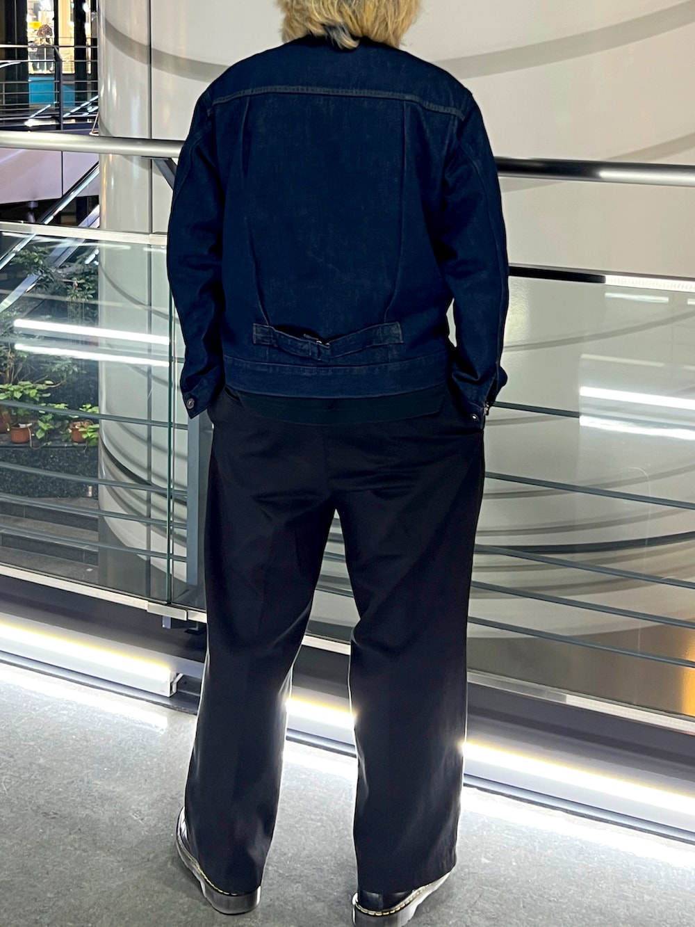 ブルー系のデニムジャケット、ブラック系のチノパンツ、ブラック系のブーツを着用したメンズの春コーディネートの2枚目の写真