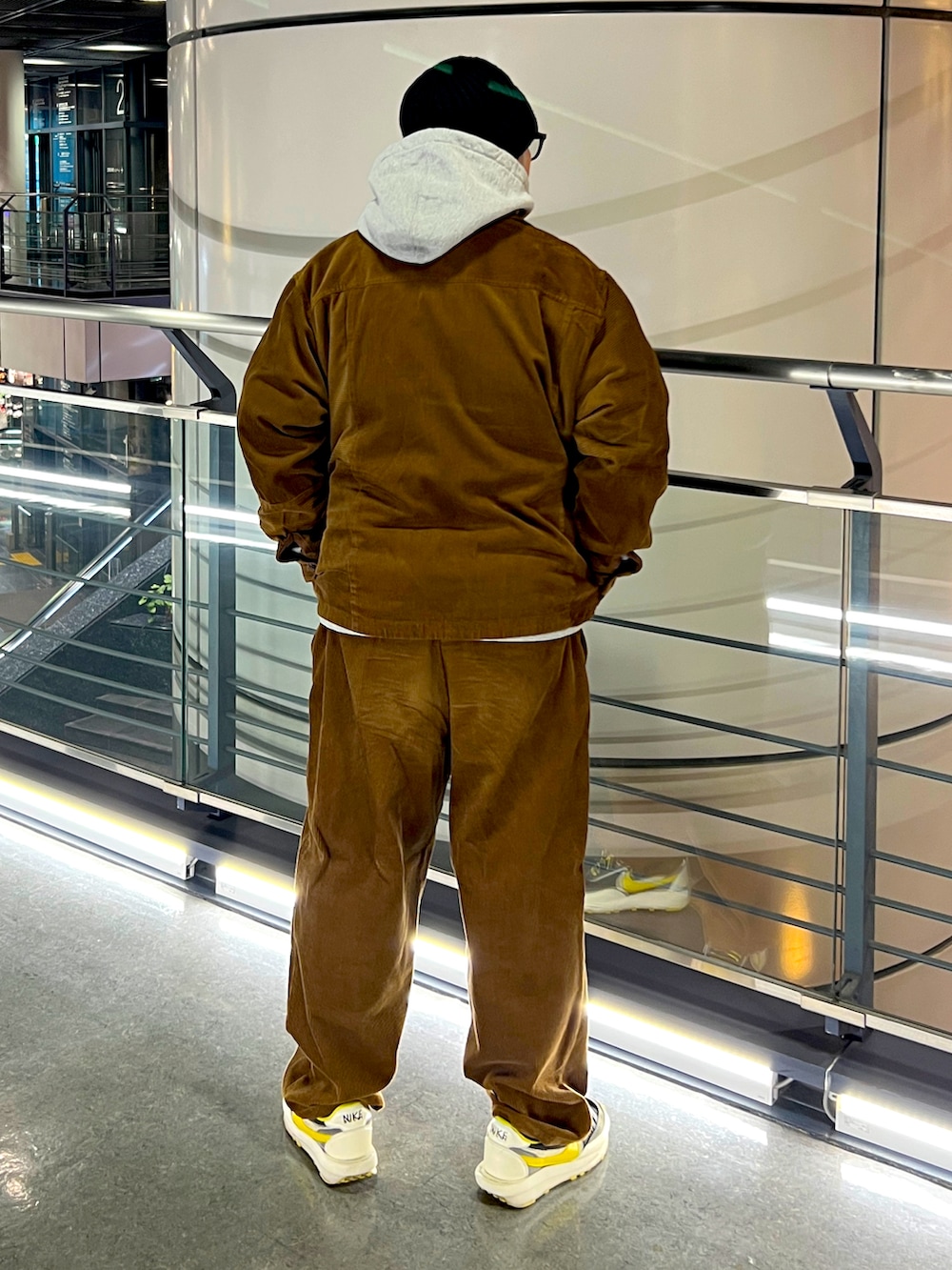 ブラウン系のブルゾン、ブラウン系のその他パンツ、グレー系のパーカーを着用したメンズの冬コーディネートの2枚目の写真