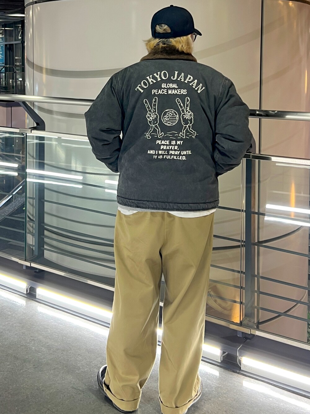 グレー系のその他アウター、ベージュ系のチノパンツ、ブラック系のブーツを着用したメンズの冬コーディネートの2枚目の写真