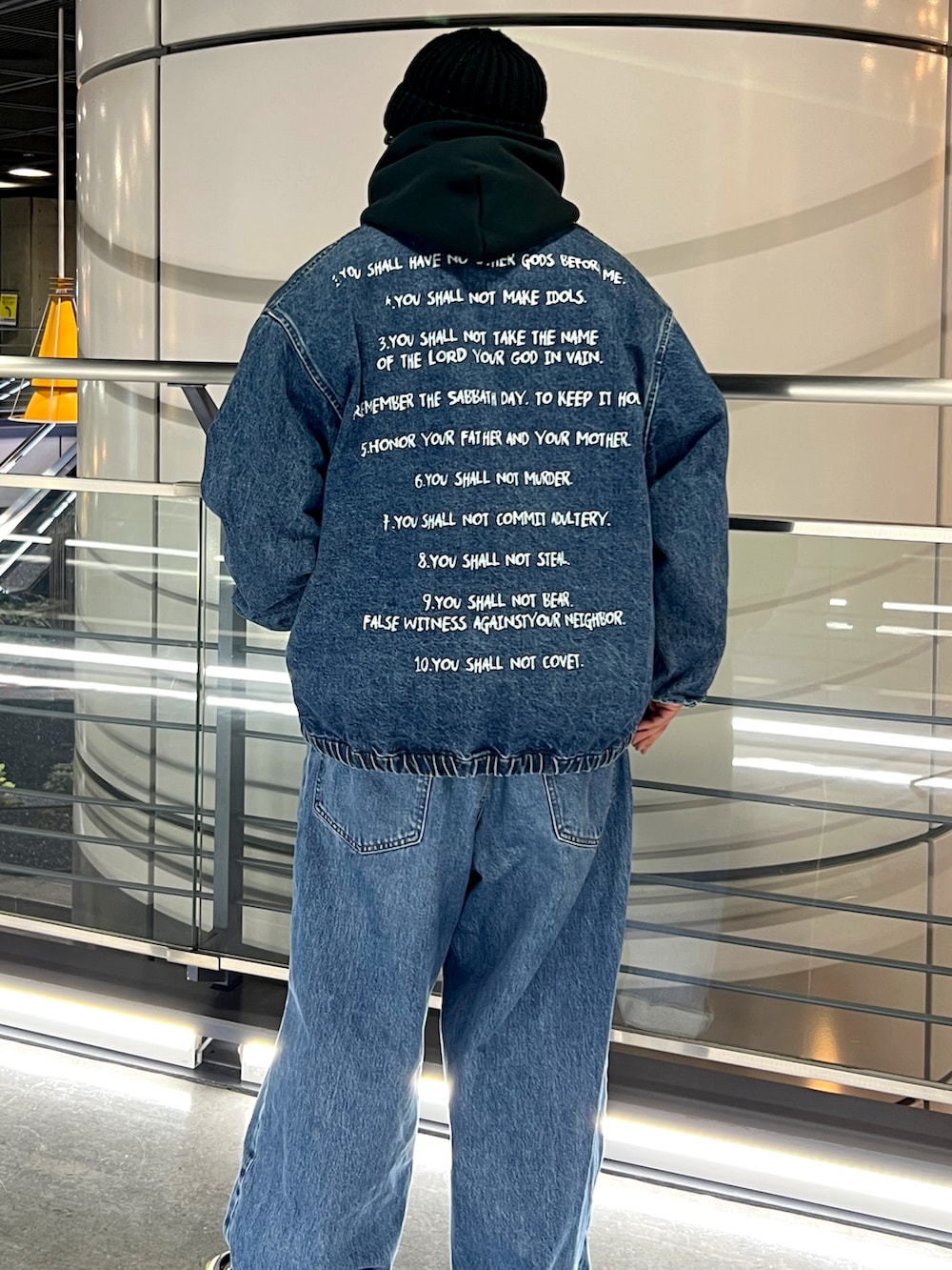 ブルー系のデニムジャケット、ブルー系のデニムパンツ、ブラック系のパーカーを着用したメンズの冬コーディネートの2枚目の写真