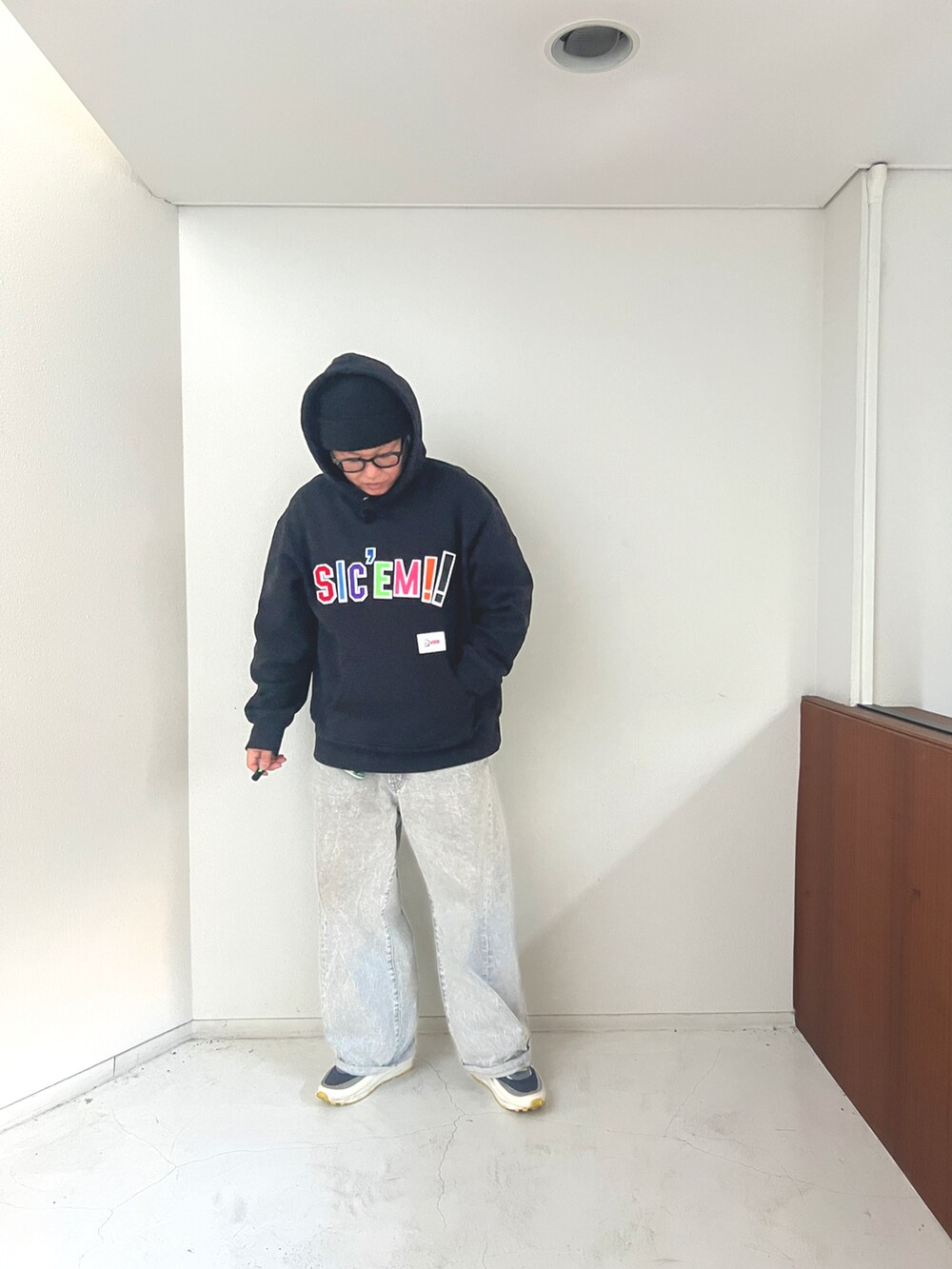 グレー系のデニムパンツ、ブラック系のダウンジャケット/コート、ブラック系のパーカーを着用したメンズの冬コーディネートの3枚目の写真