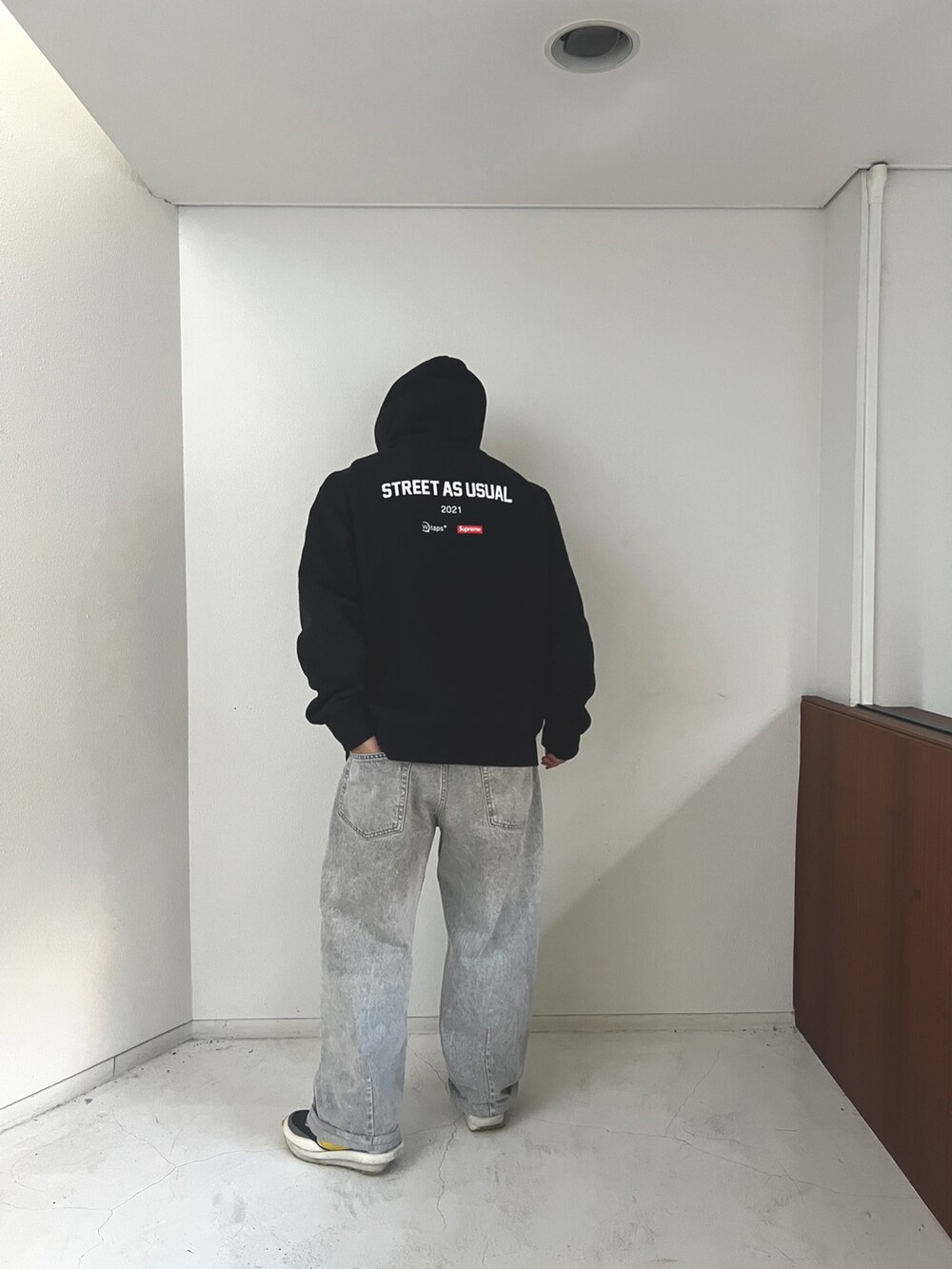 グレー系のデニムパンツ、ブラック系のダウンジャケット/コート、ブラック系のパーカーを着用したメンズの冬コーディネートの4枚目の写真