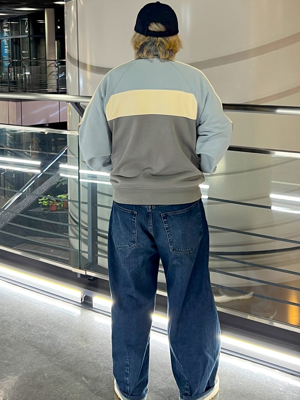 ベージュ系のその他アウター、ブルー系のデニムパンツ、ブラック系のキャップを着用したメンズの春コーディネートの2枚目の写真