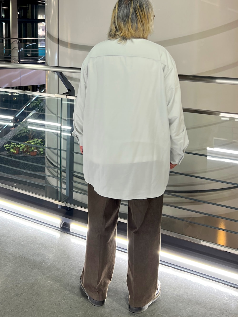 ホワイト系のシャツ/ブラウス、ブラウン系のチノパンツ、ブラック系のブーツを着用したメンズの春コーディネートの2枚目の写真