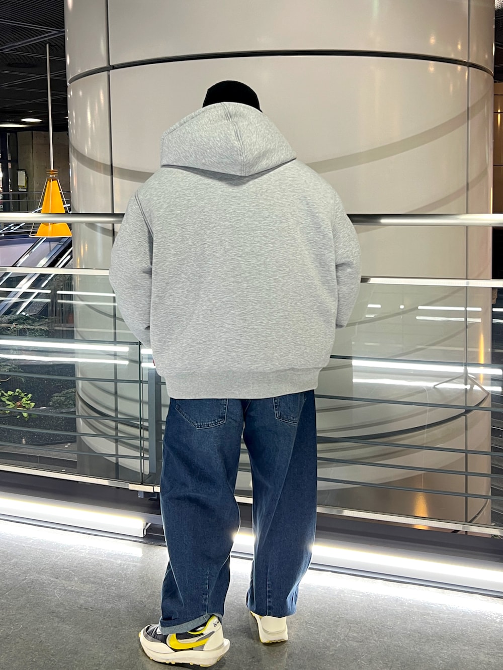 グレー系のダウンジャケット/コート、ブルー系のニット/セーター、ブラック系のニットキャップ/ビーニーを着用したメンズの冬コーディネートの3枚目の写真