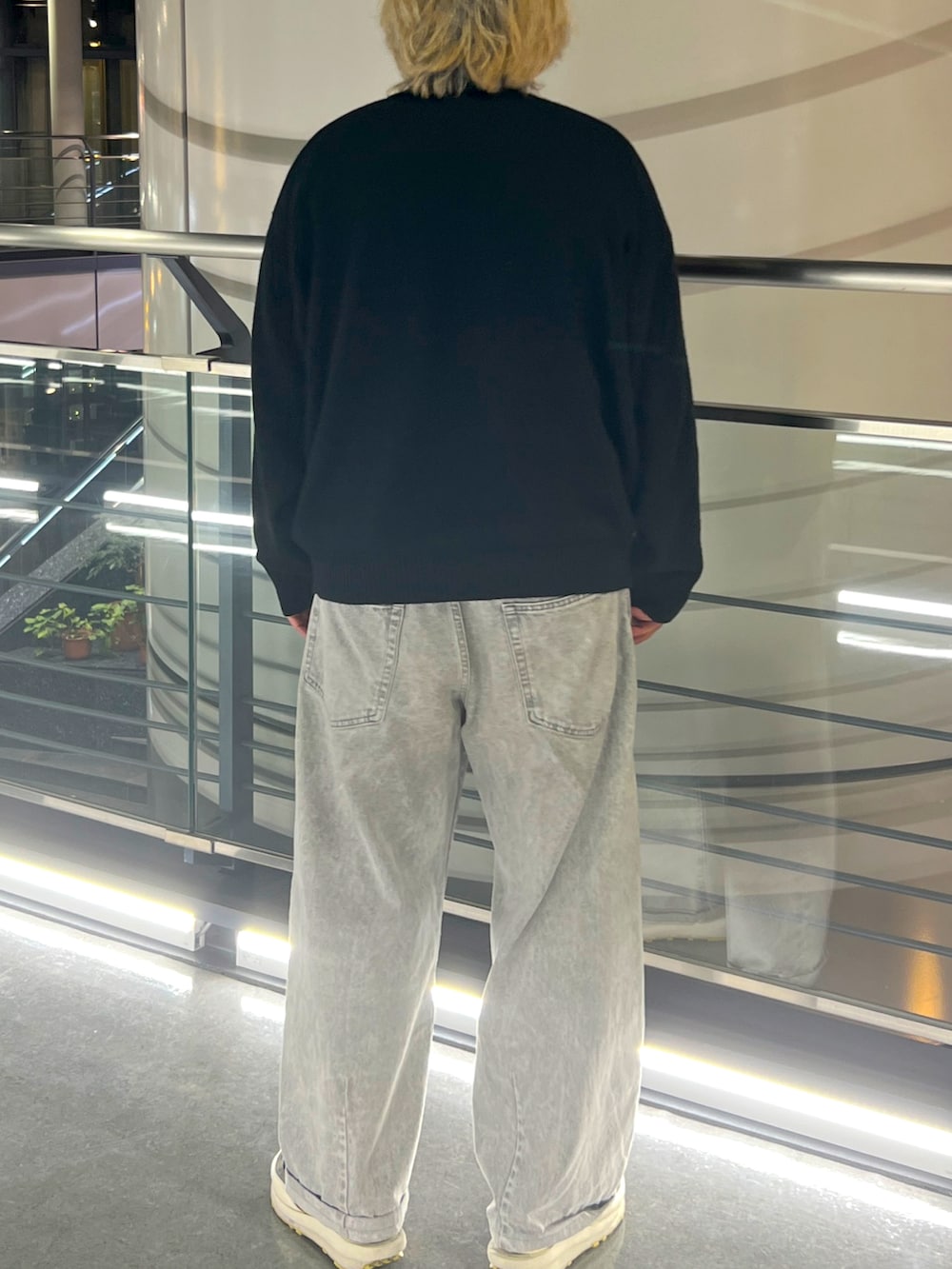 ブラック系のカーディガン/ボレロ、グレー系のデニムパンツ、ブラック系のスニーカーを着用したメンズの春コーディネートの2枚目の写真