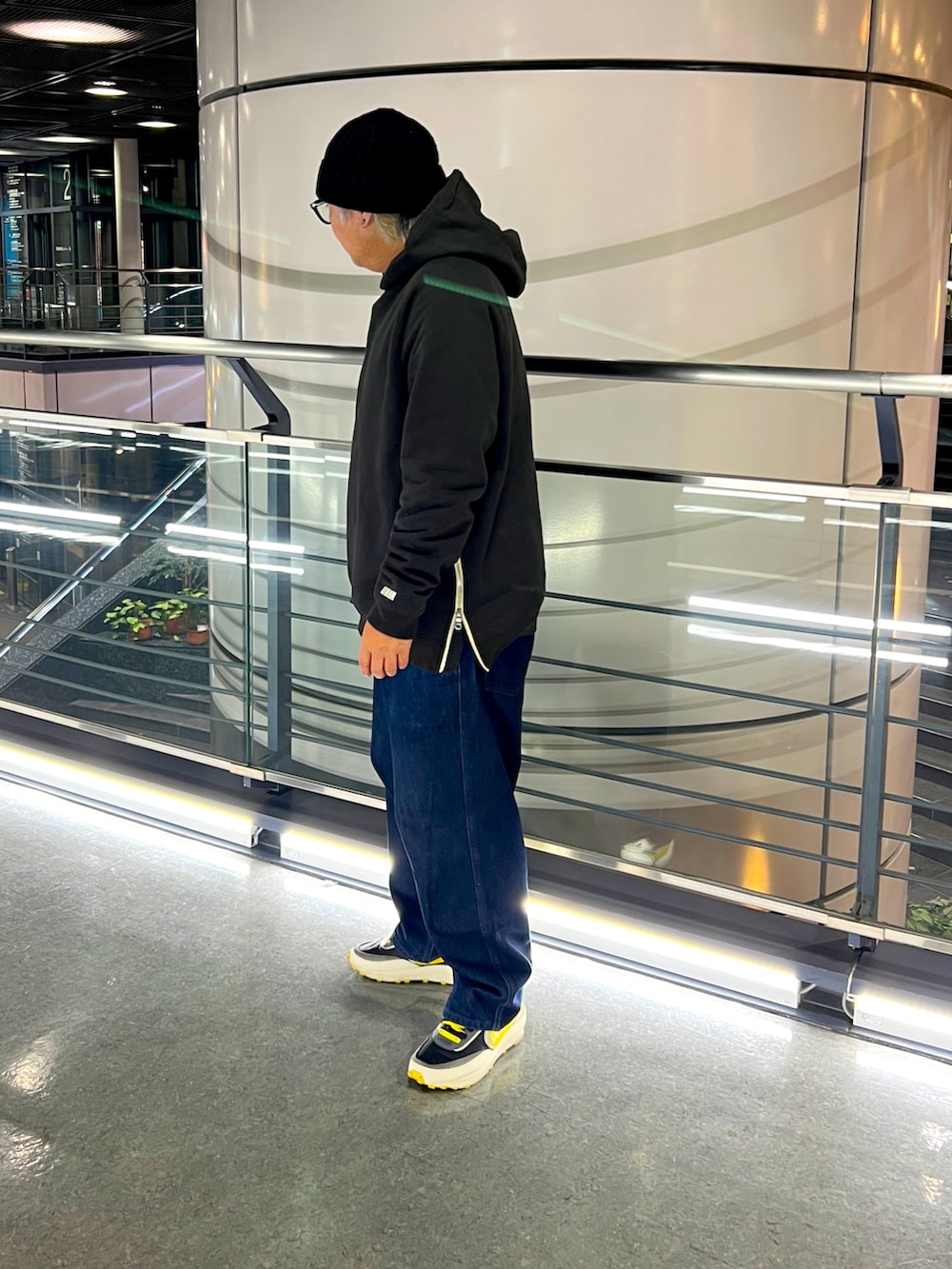 ブラック系のパーカー、ブルー系のデニムパンツを着用したメンズの冬コーディネートの2枚目の写真