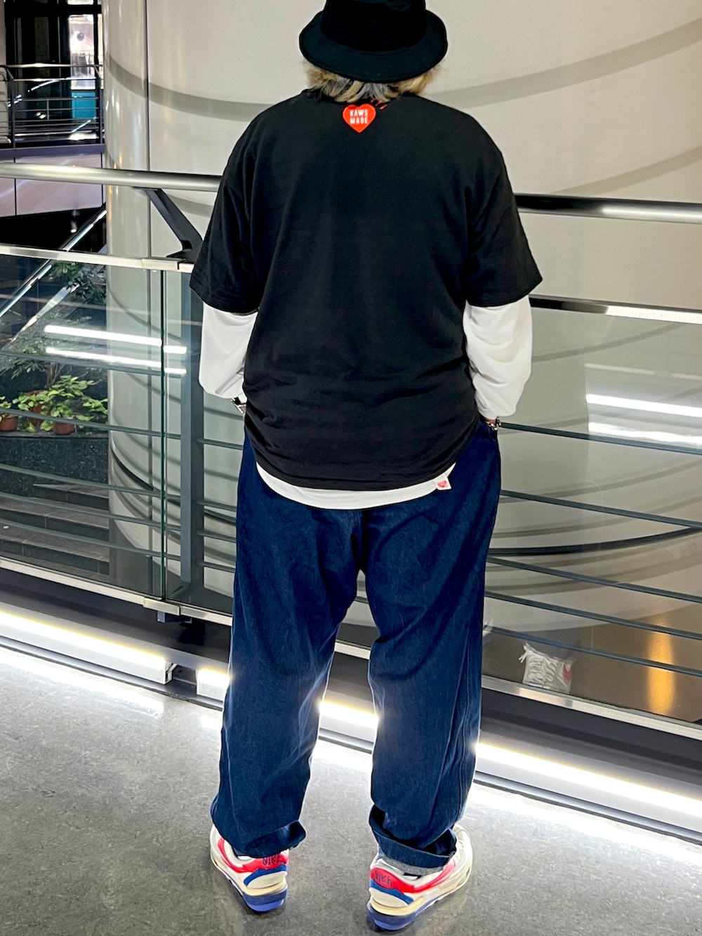 ブラック系のTシャツ/カットソー、ブルー系のデニムパンツ、ホワイト系のスニーカーを着用したメンズの春コーディネートの2枚目の写真