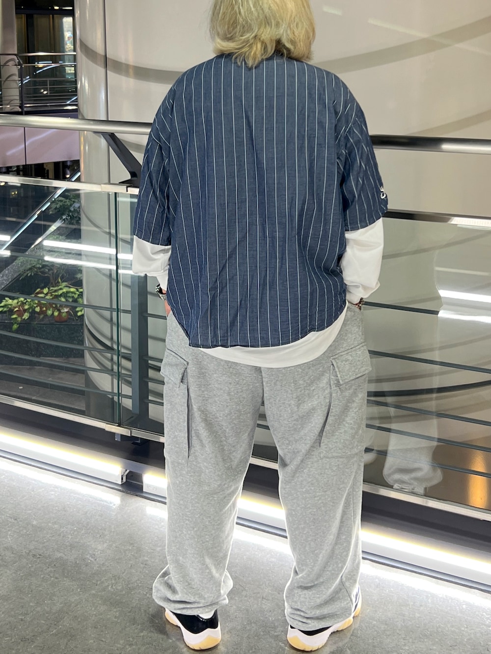 ブルー系のシャツ/ブラウス、グレー系のスウェットパンツ、ホワイト系のスニーカーを着用したメンズの夏コーディネートの2枚目の写真