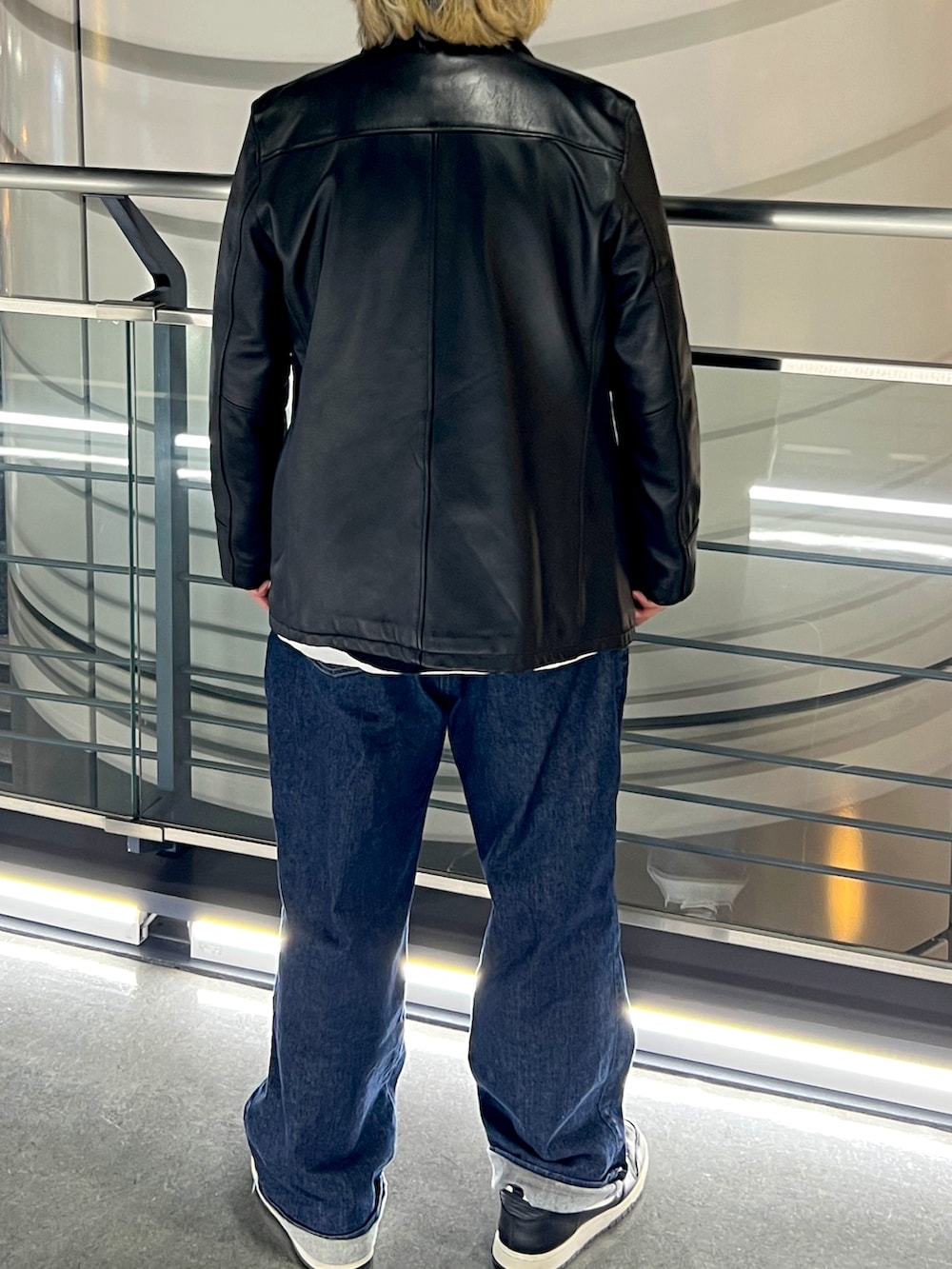 ブラック系のその他アウター、ブルー系のデニムパンツ、ブラック系のスニーカーを着用したメンズの春コーディネートの2枚目の写真