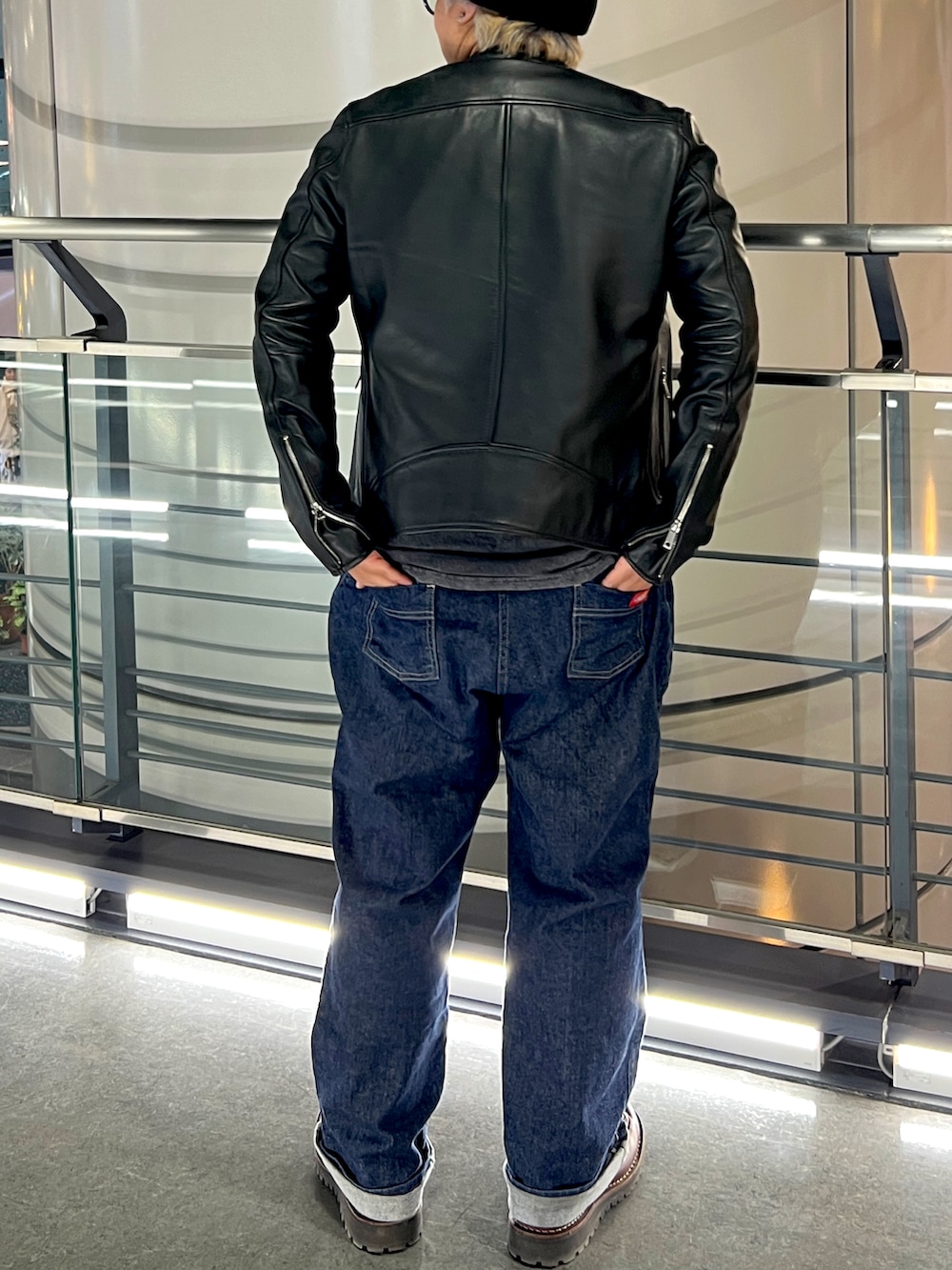 ブラウン系のブーツ、ブルー系のデニムパンツ、ブラック系のピーコートを着用したメンズの冬コーディネートの4枚目の写真