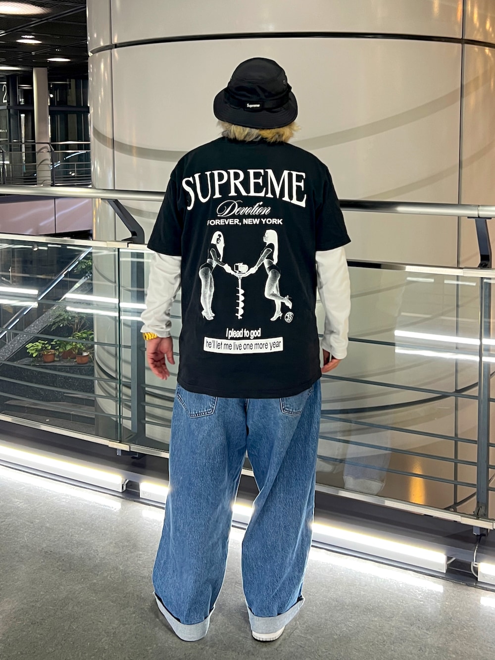 ブラック系のTシャツ/カットソー、ブルー系のデニムパンツ、グレー系のスニーカーを着用したメンズの春コーディネートの2枚目の写真