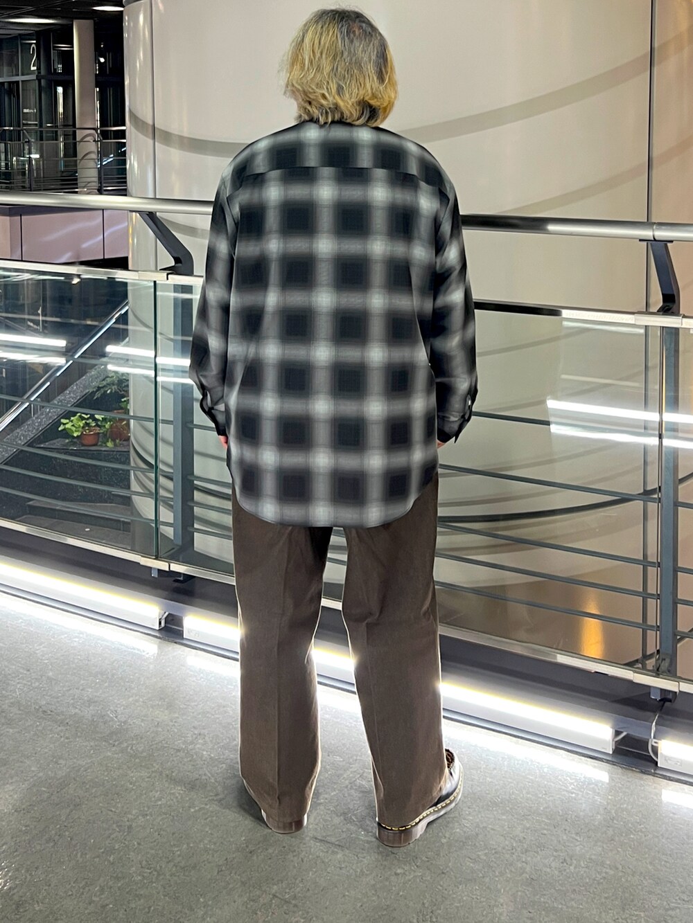 ブラック系のシャツ/ブラウス、ブラウン系のチノパンツ、ブラック系のローファーを着用したメンズの春コーディネートの2枚目の写真
