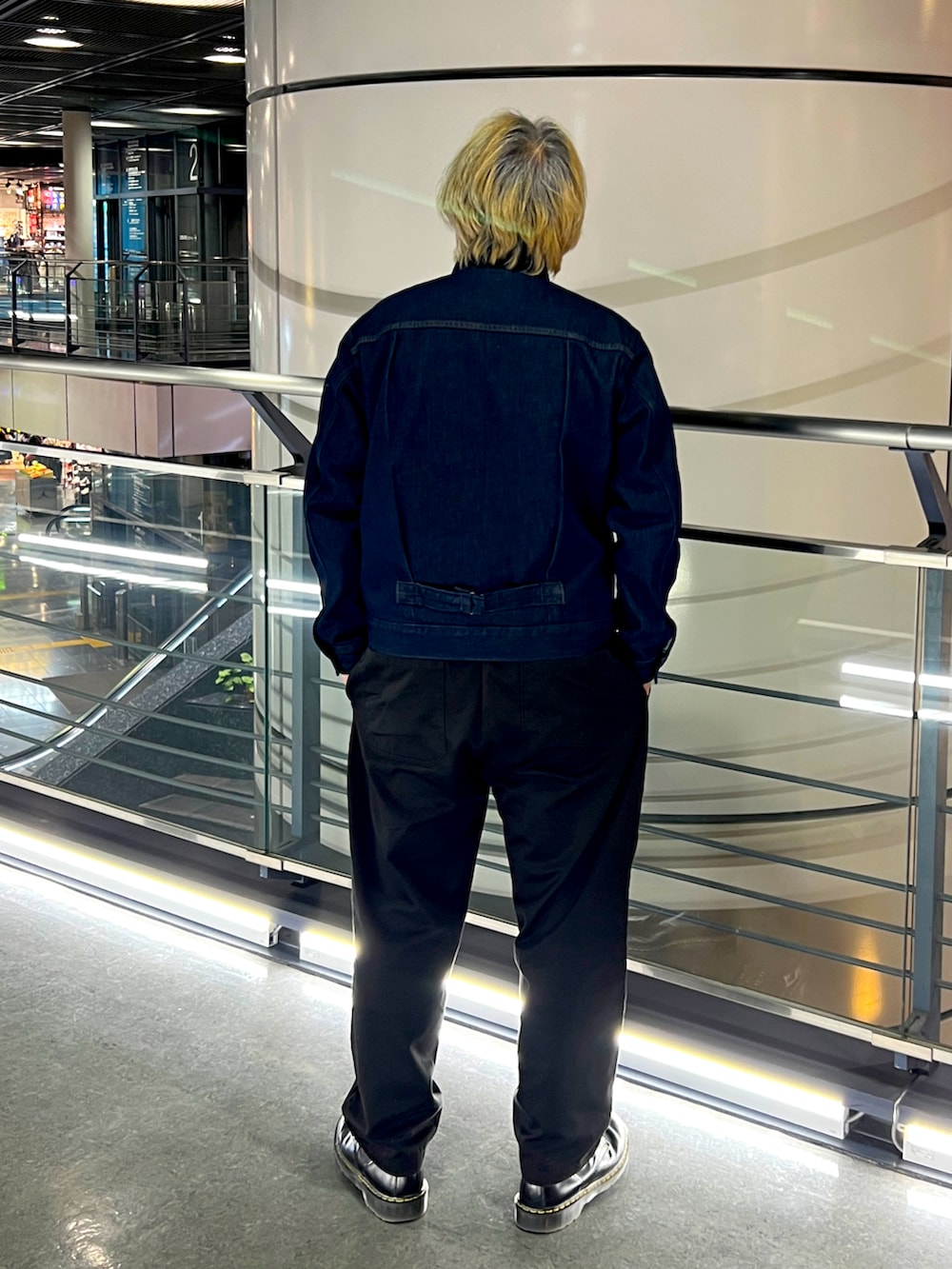 ブルー系のデニムジャケット、ブラック系のチノパンツ、ブラック系のブーツを着用したメンズの冬コーディネートの2枚目の写真