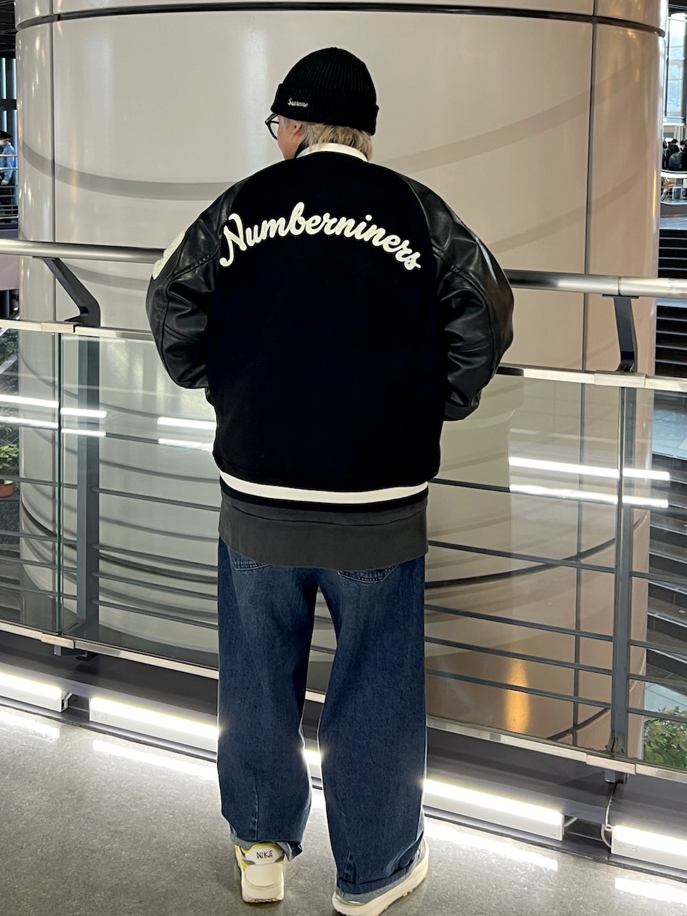 ブラック系のスタジャン、ブルー系のデニムパンツ、ブラック系のスニーカーを着用したメンズの冬コーディネートの2枚目の写真