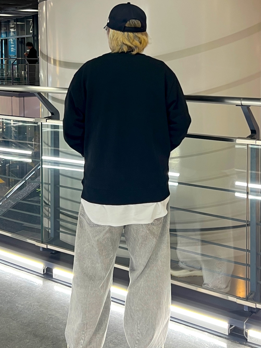 ブラック系のスウェット、グレー系のデニムパンツ、ブラック系のキャップを着用したメンズの春コーディネートの2枚目の写真