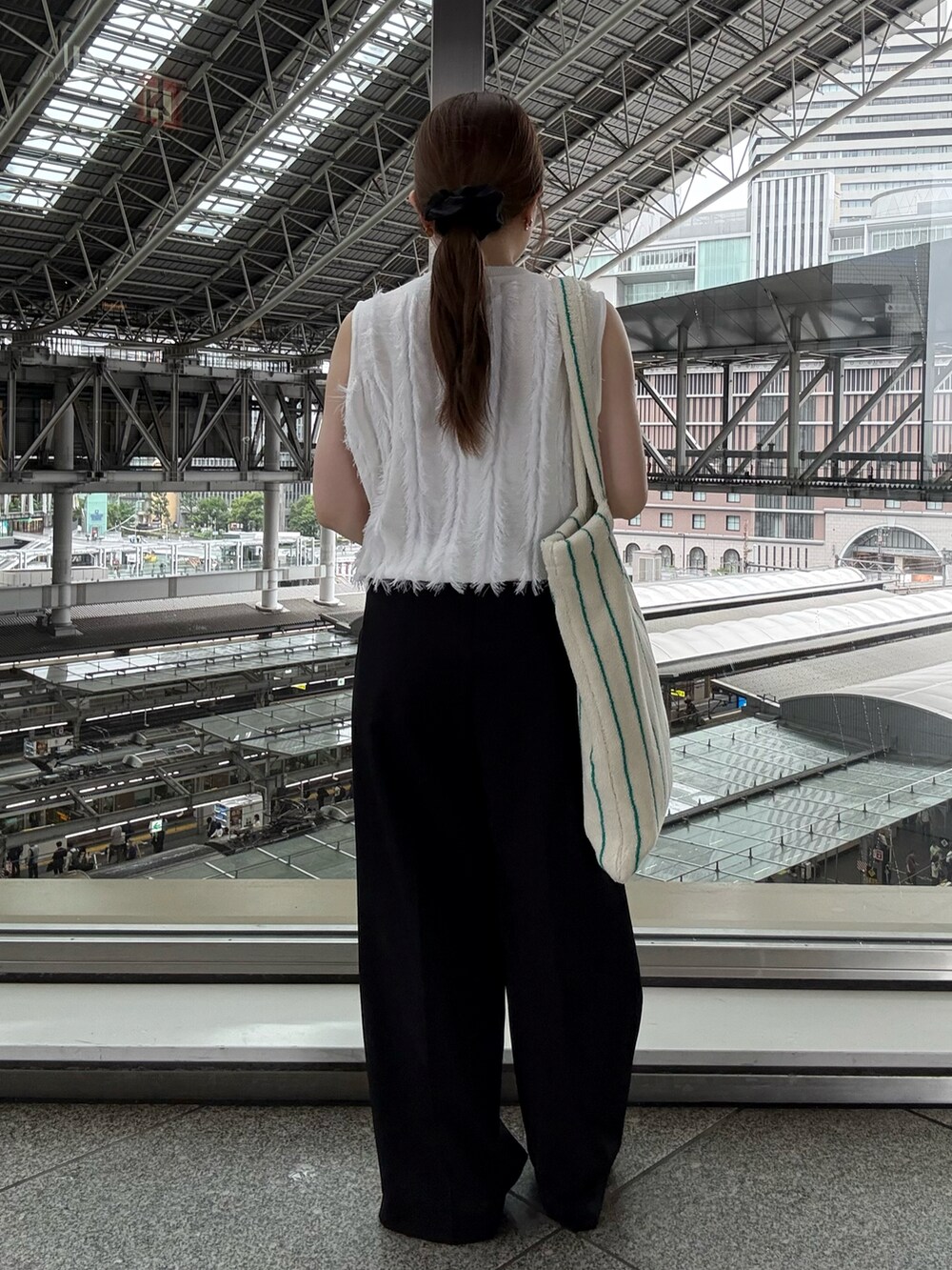 ブラック系のローファー、ホワイト系のニット/セーター、ブラック系のスラックスを着用したレディースの夏コーディネートの3枚目の写真